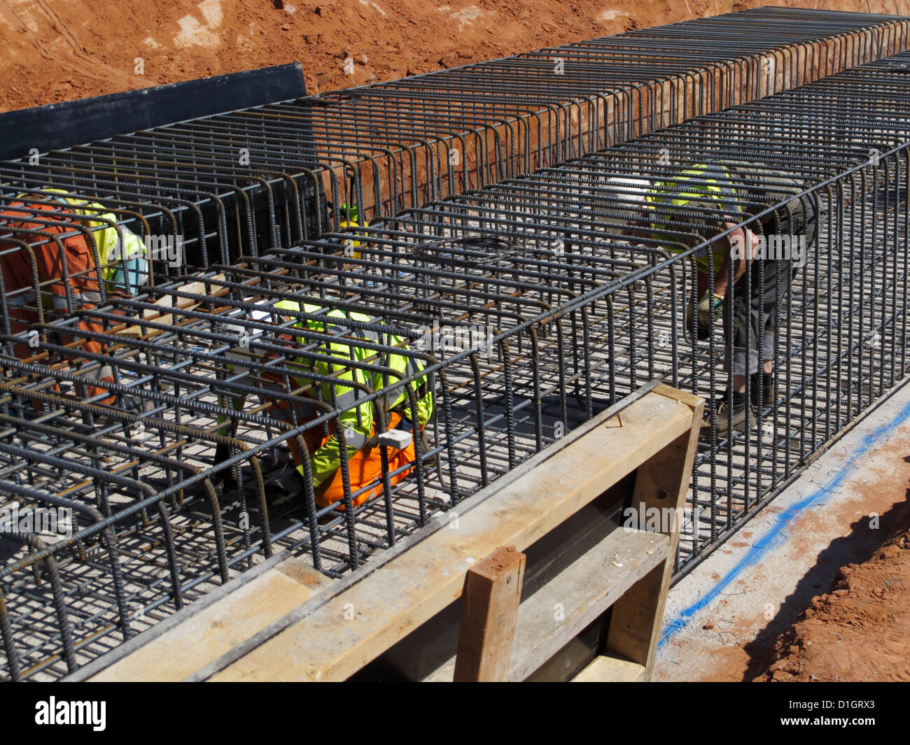 Steel fixer tying reinforcement bars in a bridge foundation base construction building site civil engineering UK Stock Photo