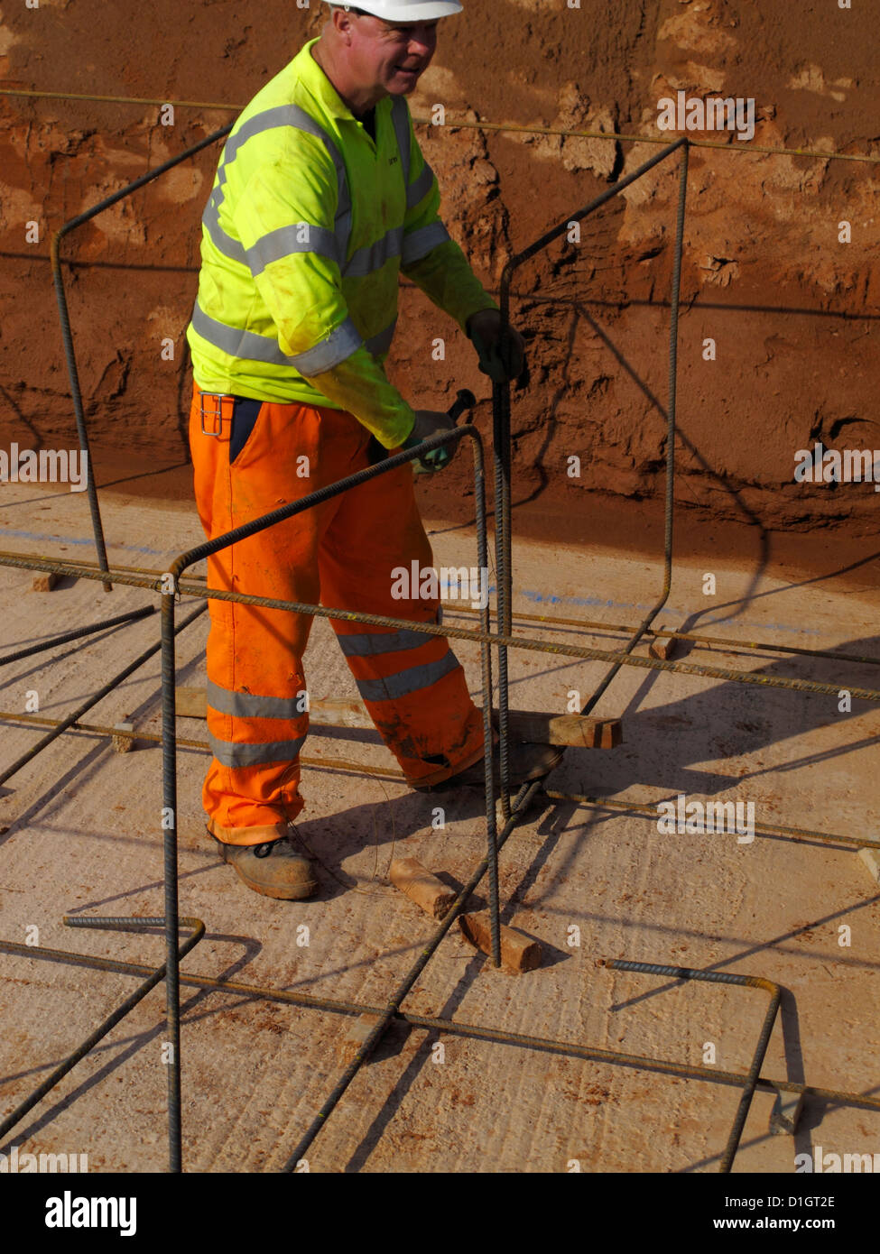 Steel fixer tying reinforcement bars in a bridge foundation base