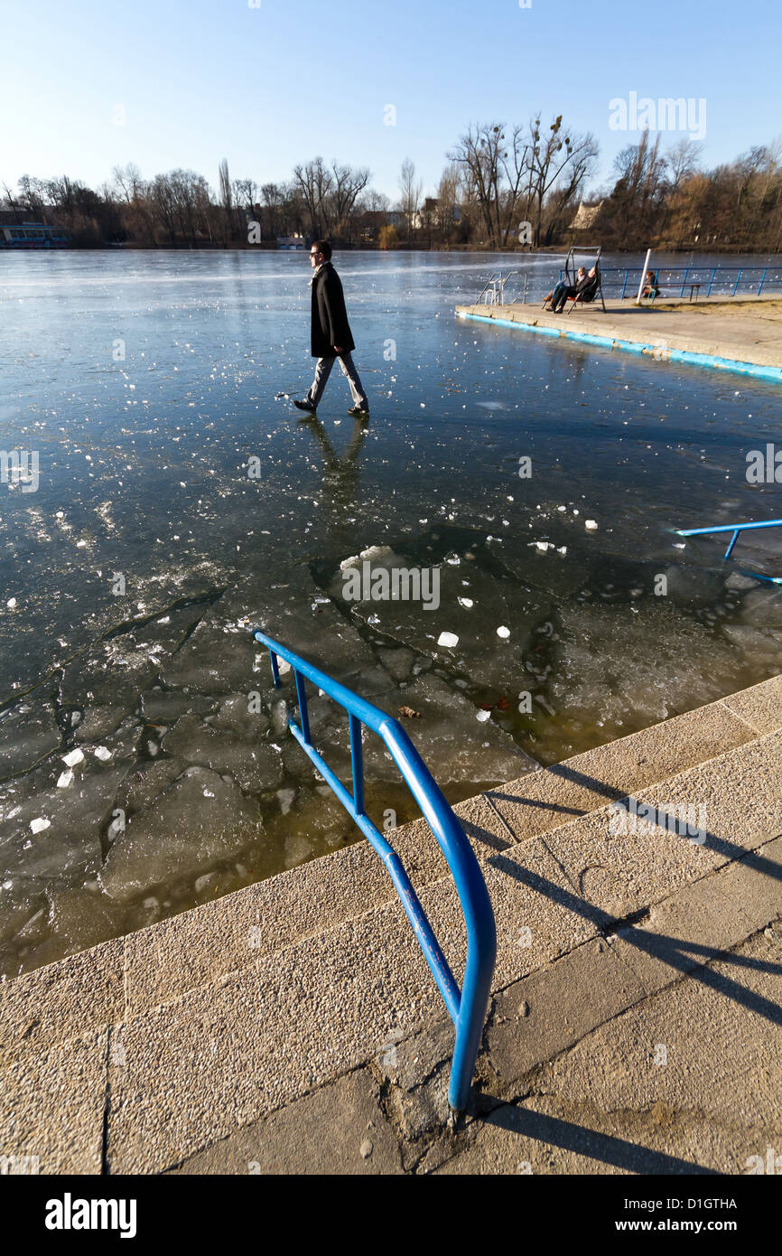 Man walking on the frozen Lake Weißensee in Berlin Pankow during Winter Time, Germany Stock Photo