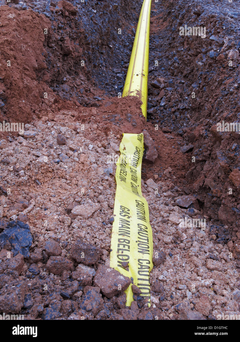 Road construction site UK trench with yellow plastic tape warning
