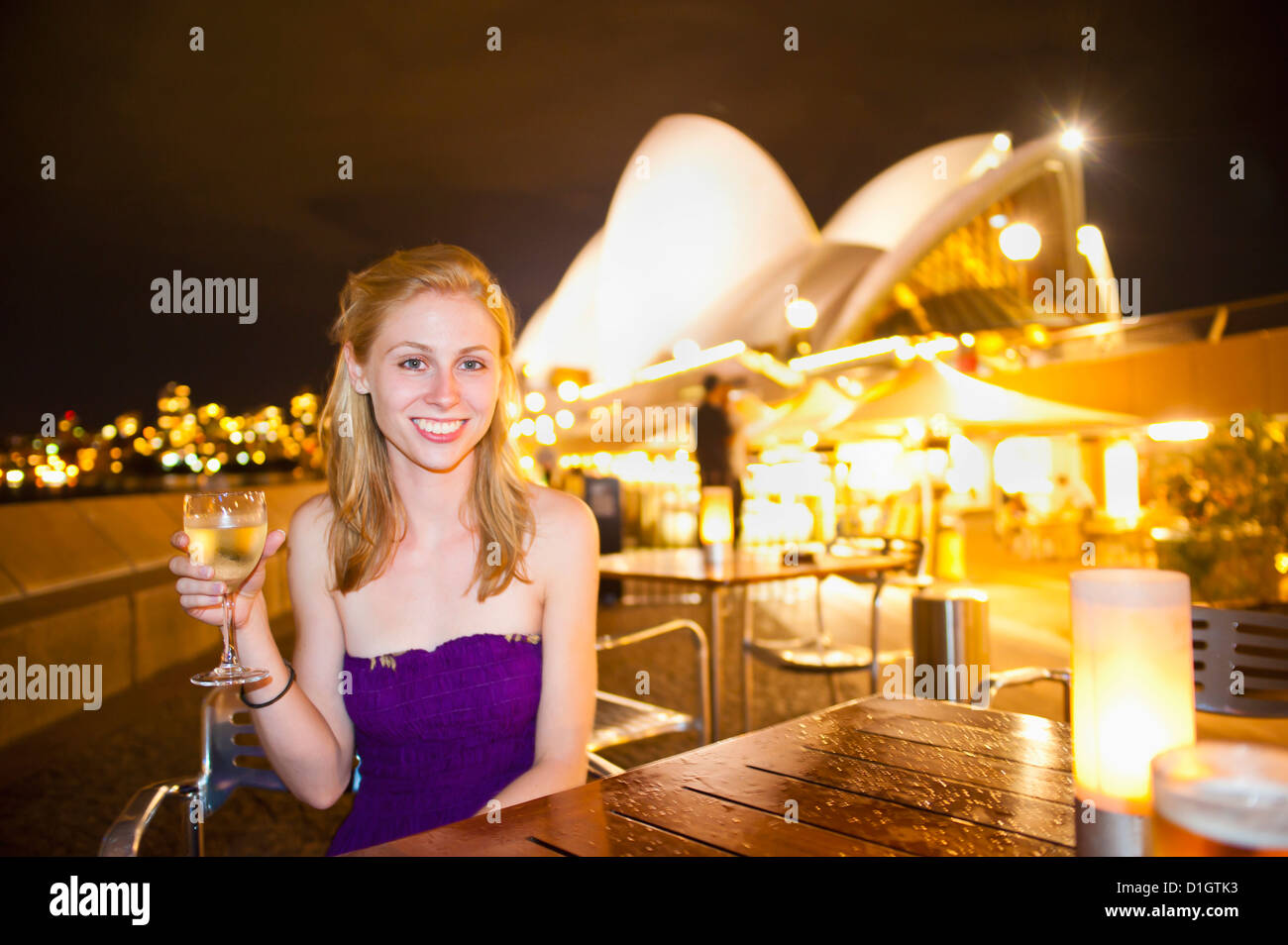 Young woman enjoying Sydney nightlife, having a drink at Opera Bar
