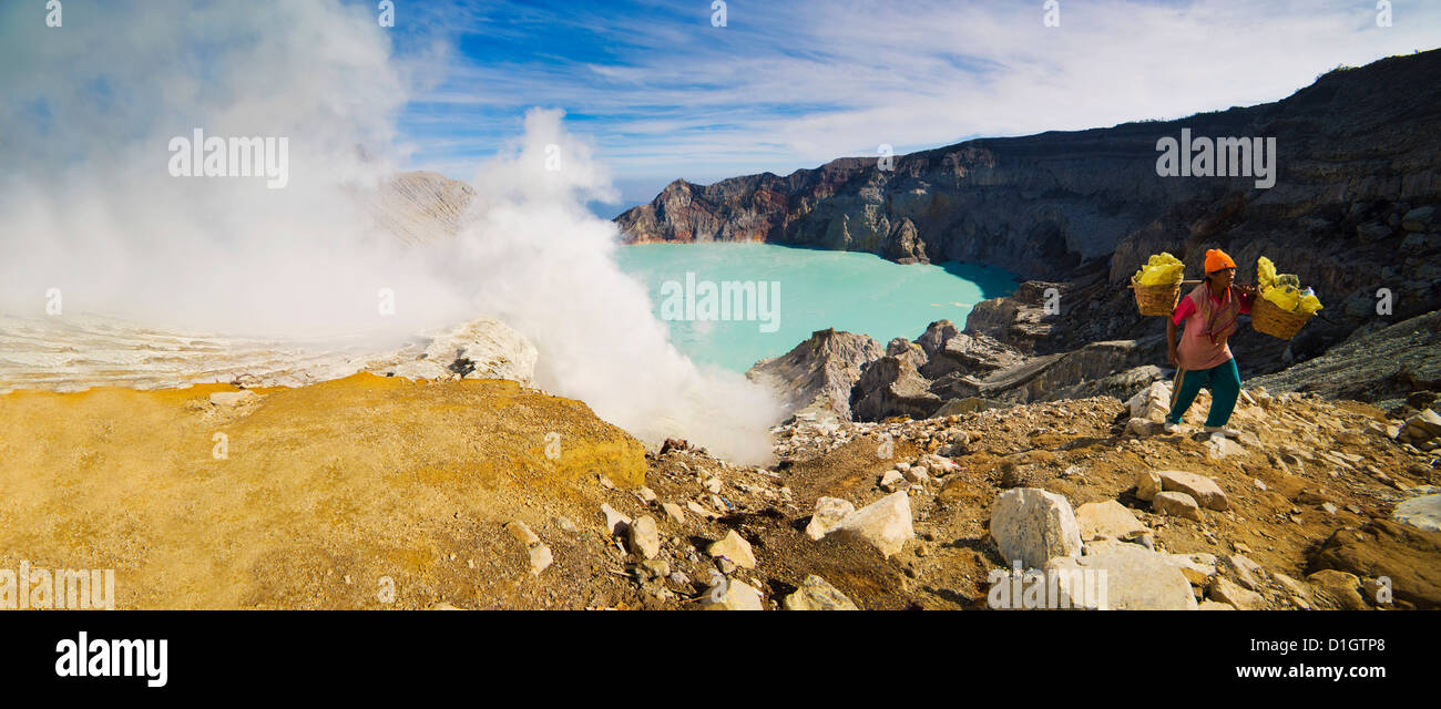 Panorama of sulphur worker appearing out of toxic fumes at Kawah Ijen volcano, East Java, Indonesia, Southeast Asia, Asia Stock Photo