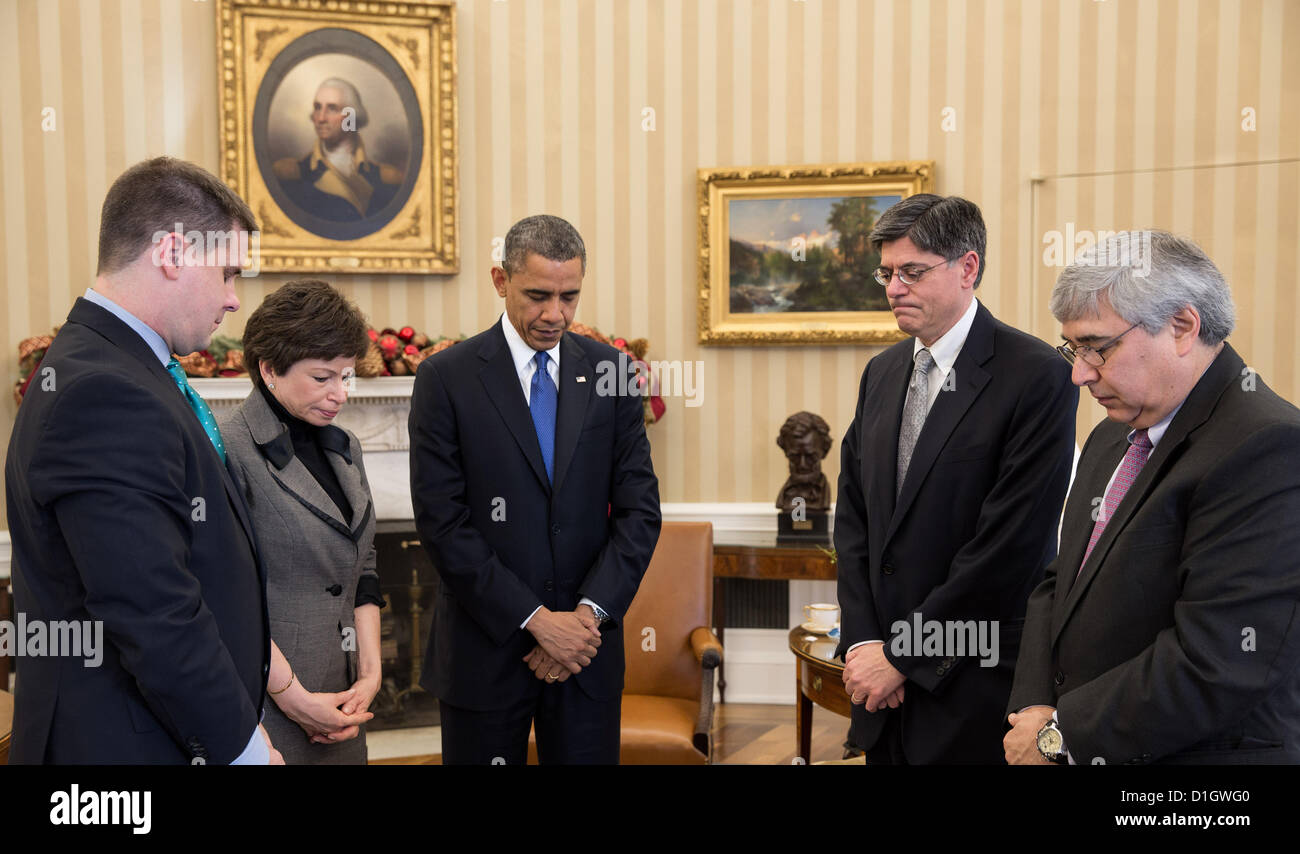 Washington, DC, USA. US President Barack Obama pauses during a meeting to observe a moment of silence in the Oval Office at 9:30 am December 21, 2012 in remembrance of the 20 children and six adults killed a week ago in the Sandy Hook Elementary School shooting in Newtown, CT. Joining the President, from left, are: Director of Communications Dan Pfeiffer; Senior Advisor Valerie Jarrett; Chief of Staff Jack Lew; and Pete Rouse, Counselor to the President. Stock Photo
