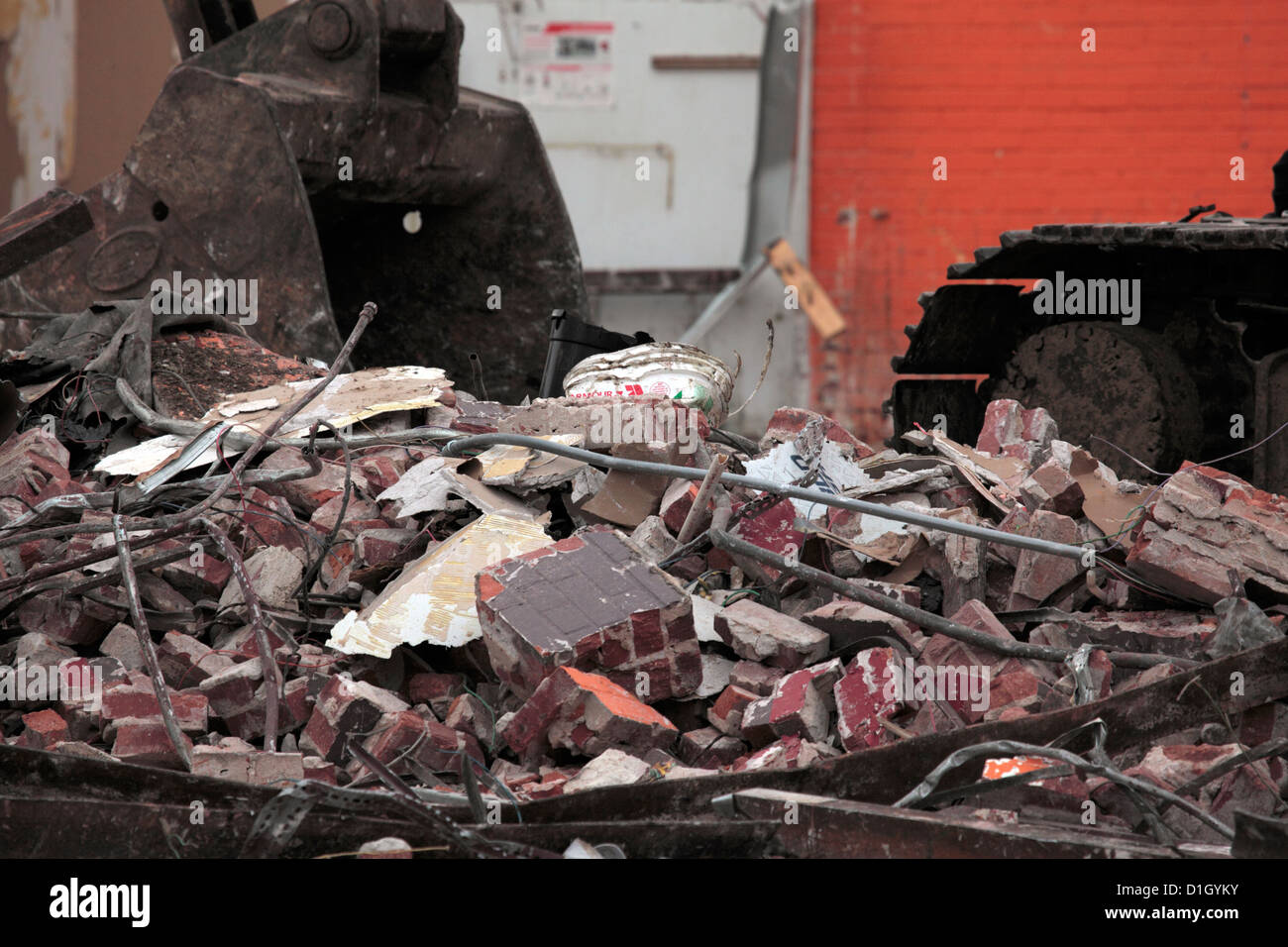 Rubble at demolition site, with tracks and bucket of excavator visible ...
