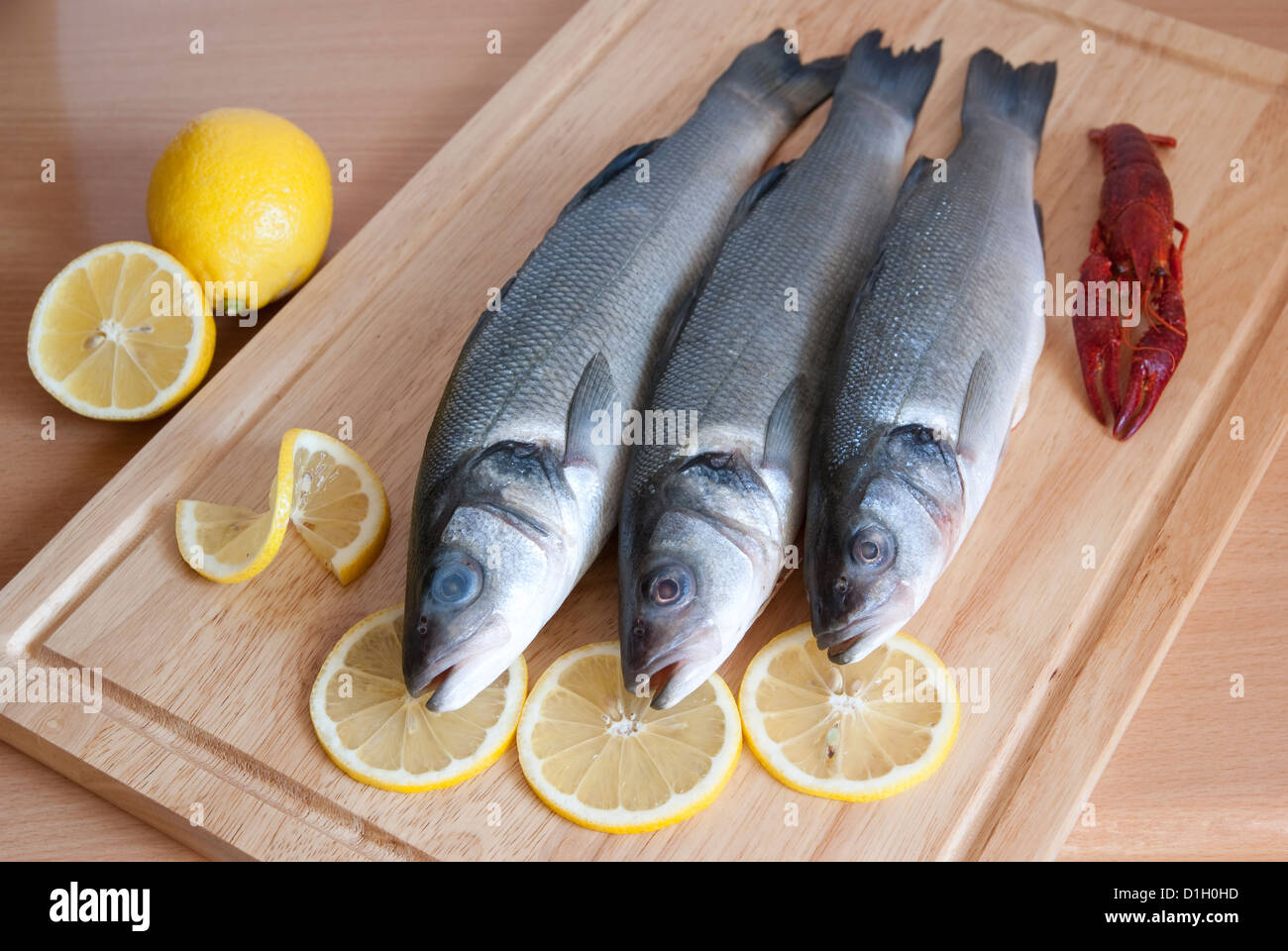fresh fish and lemon slices on plank Stock Photo
