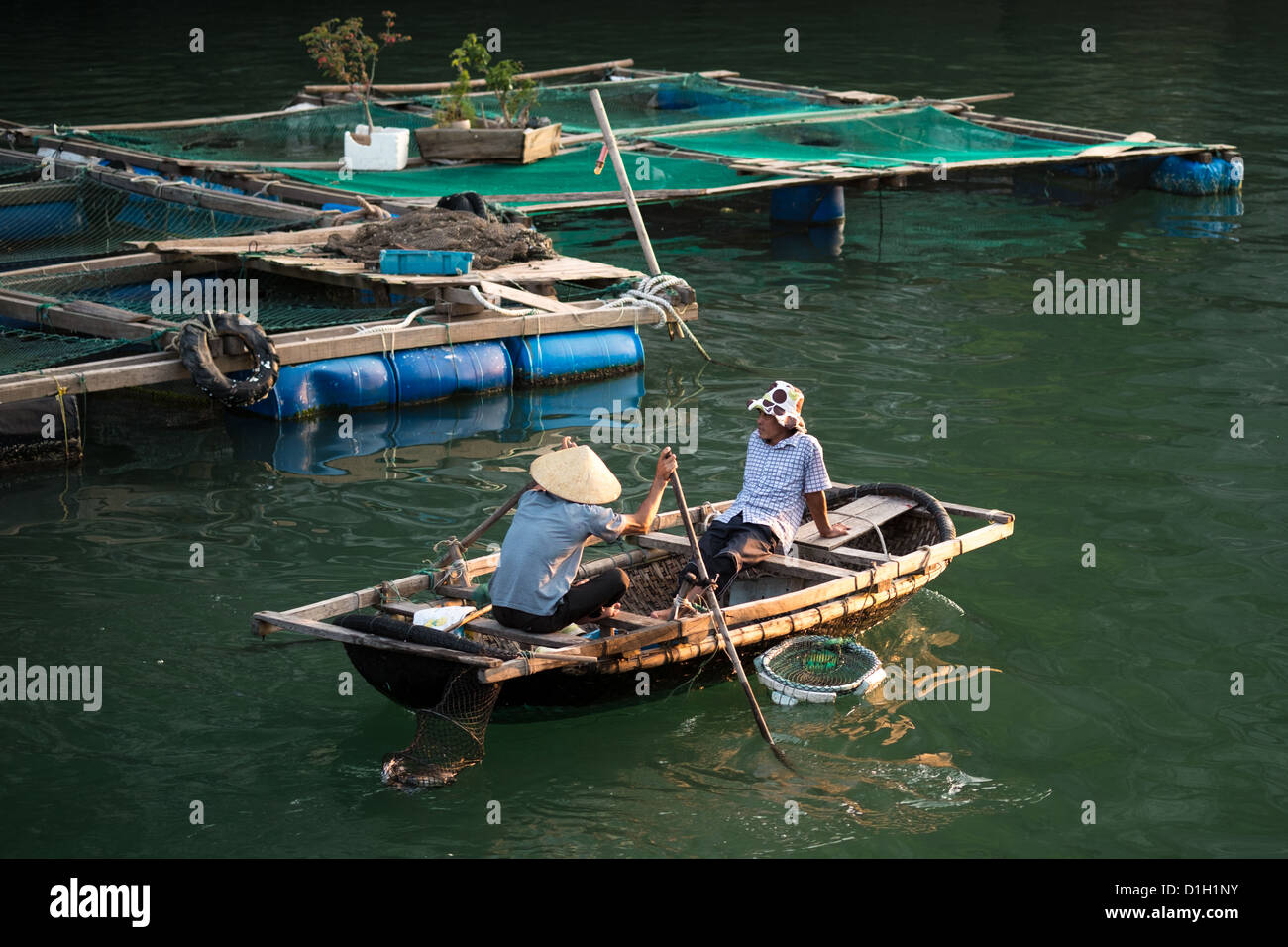 https://c8.alamy.com/comp/D1H1NY/two-local-inhabitants-rowing-past-a-wooden-floating-platform-covered-D1H1NY.jpg