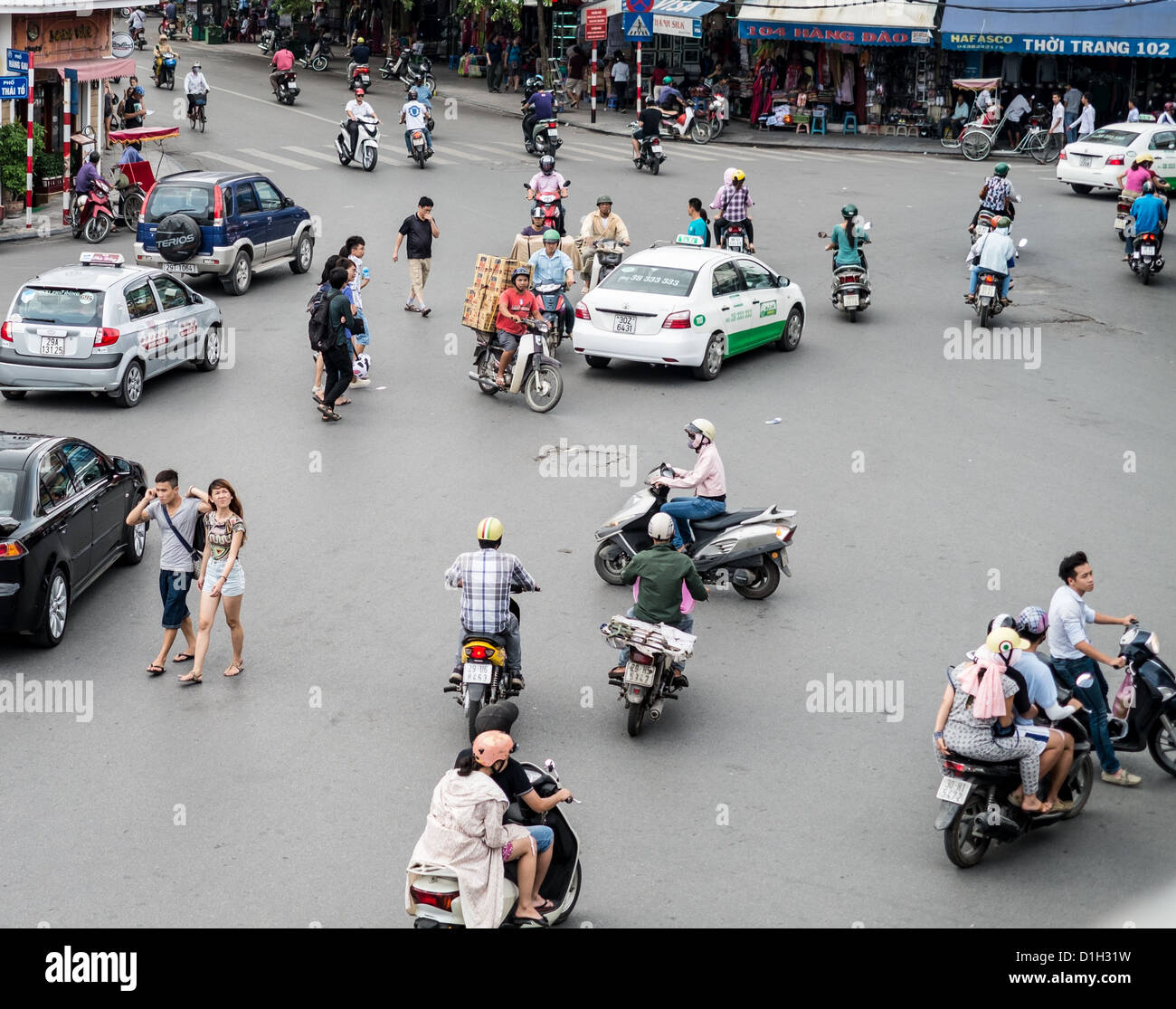 Pedestrians, mopeds and cars all find a way of working together in Hanoi, Vietnam Stock Photo