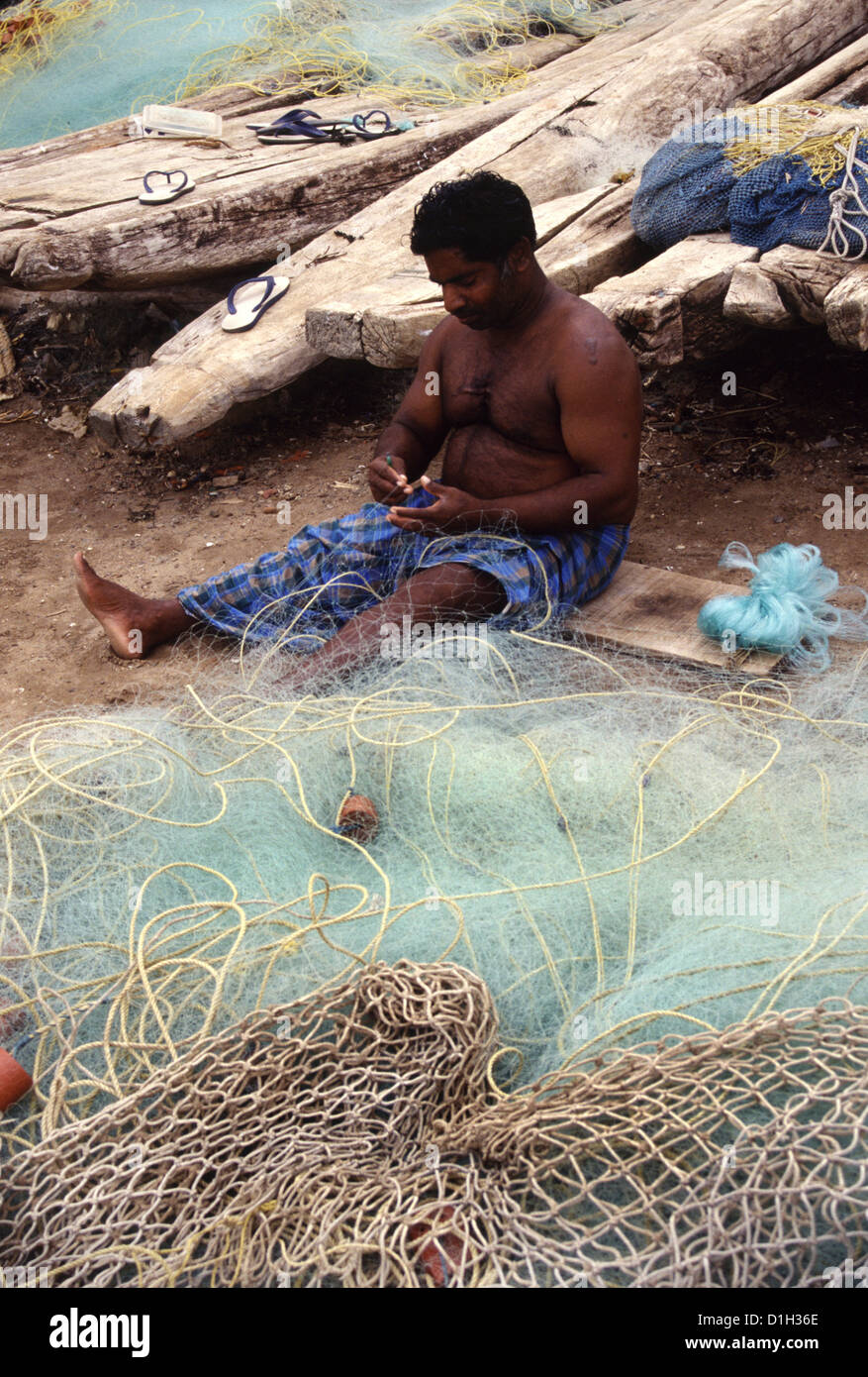 A fisherman mending nets at Mamalpuram beach Tamil Nadu South