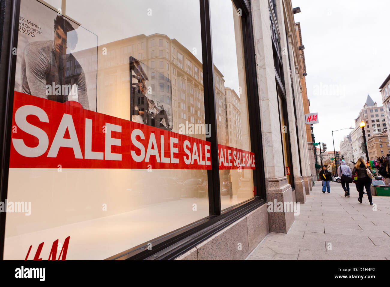 People walking by H&M clothing store window display - Washington, DC USA Stock Photo