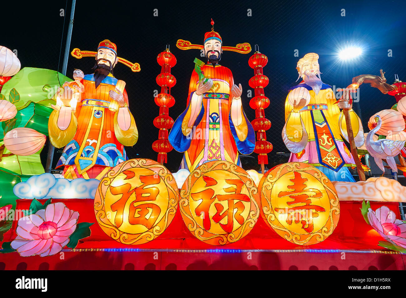 Chinese New Year God of Prosperity Good Fortune and Longevity Statues with Text Symbol Lit at Night Stock Photo