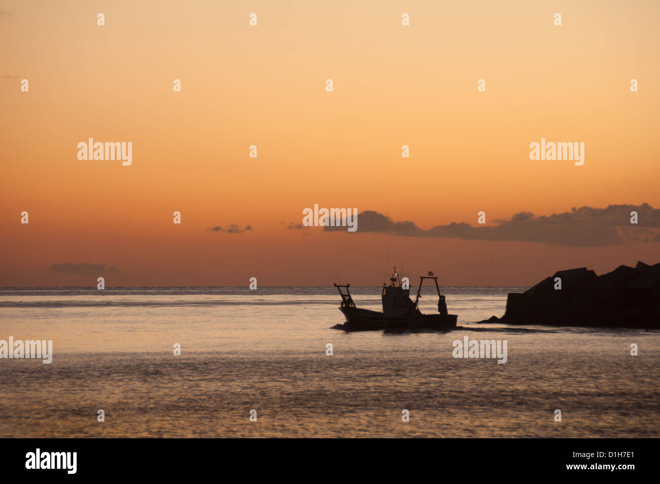 A Spanish fishing boat leaves the port at sunrise Stock Photo