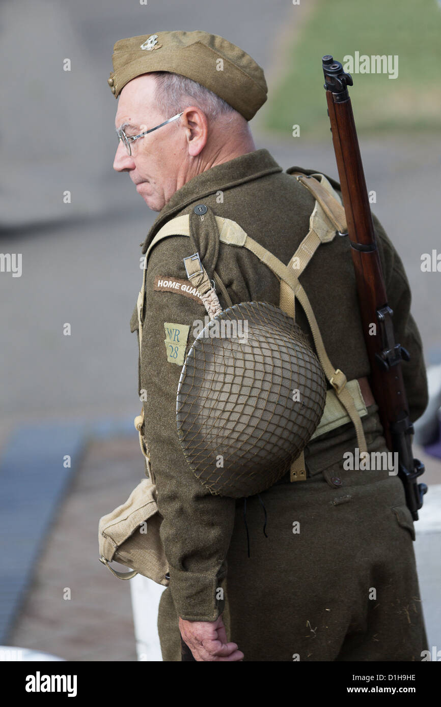 1940's Recreation - British Home Guard Soldier with Brodie Helmet, Forage Cap & Lee Enfield Rifle Stock Photo