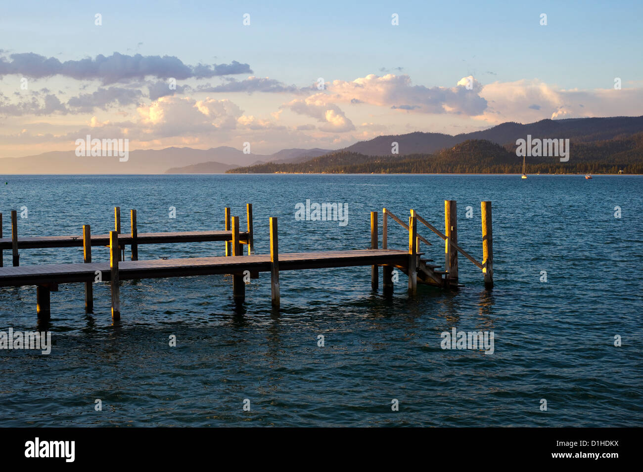 A pier is illuminated at sunset in South Lake Tahoe, CA. Stock Photo
