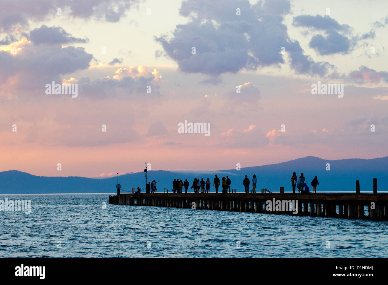 A silhouette of people enjoying a beautiful sunset from a pier in South Lake Tahoe, CA. Stock Photo