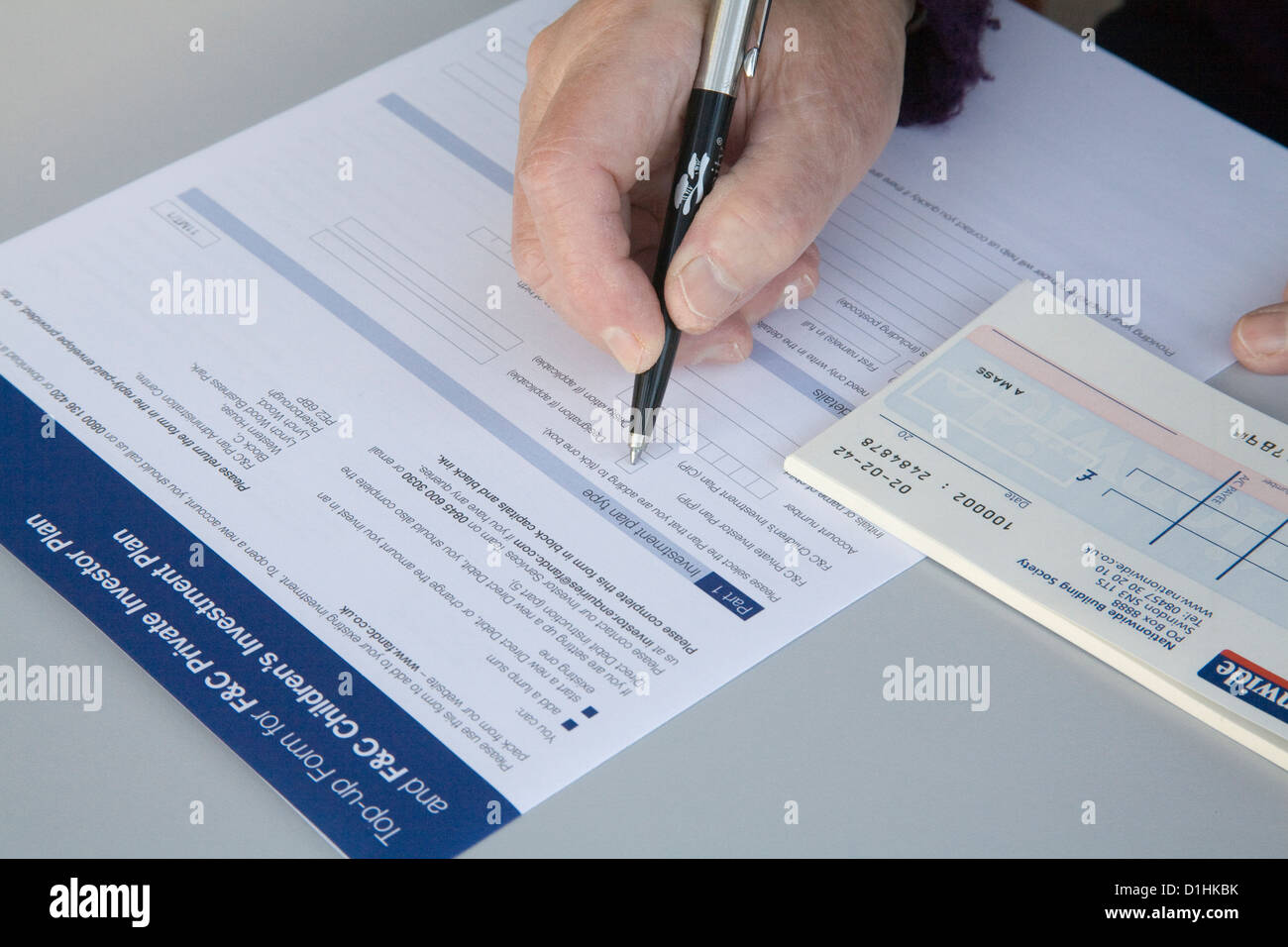 Close up Grandmother completing application for grandchild's investment plan Stock Photo