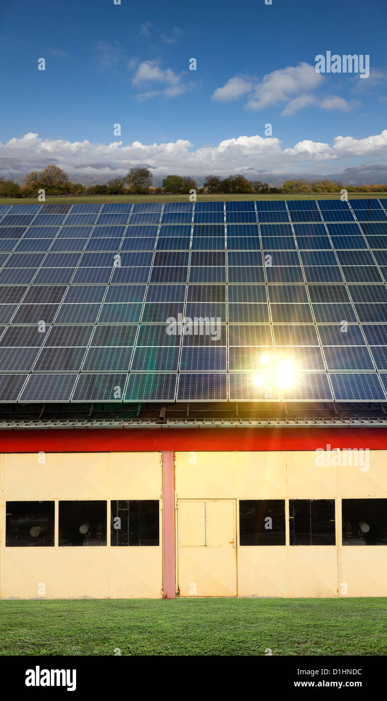 small factory with a small solar panel on the roof and an idyllic ...