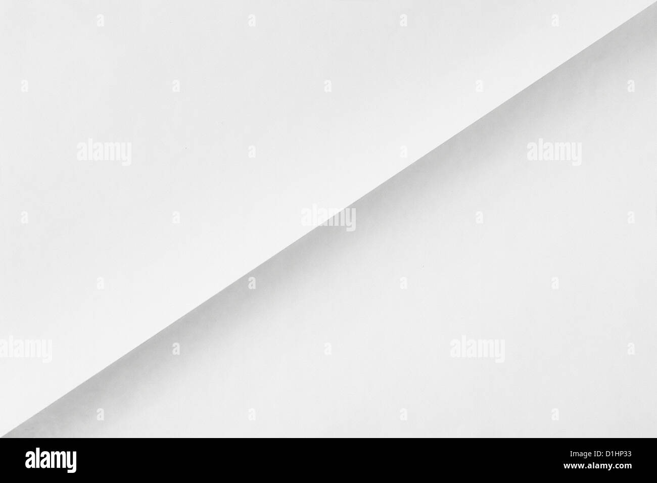 white sheet of paper folded in two diagonally with texture Stock Photo