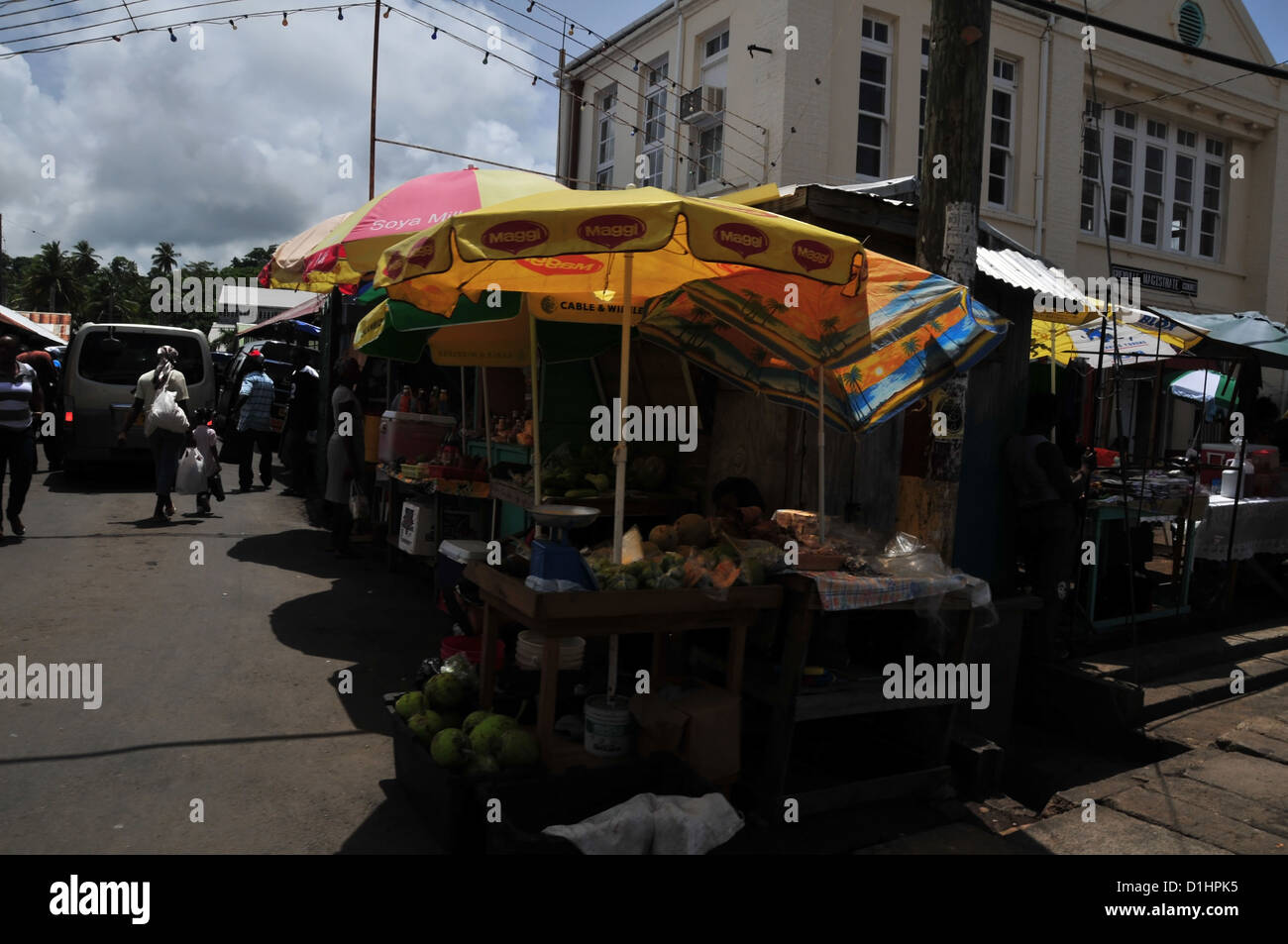 Sunny colourful umbrellas rising above Saturday roadside market stalls, front Magistrates Court