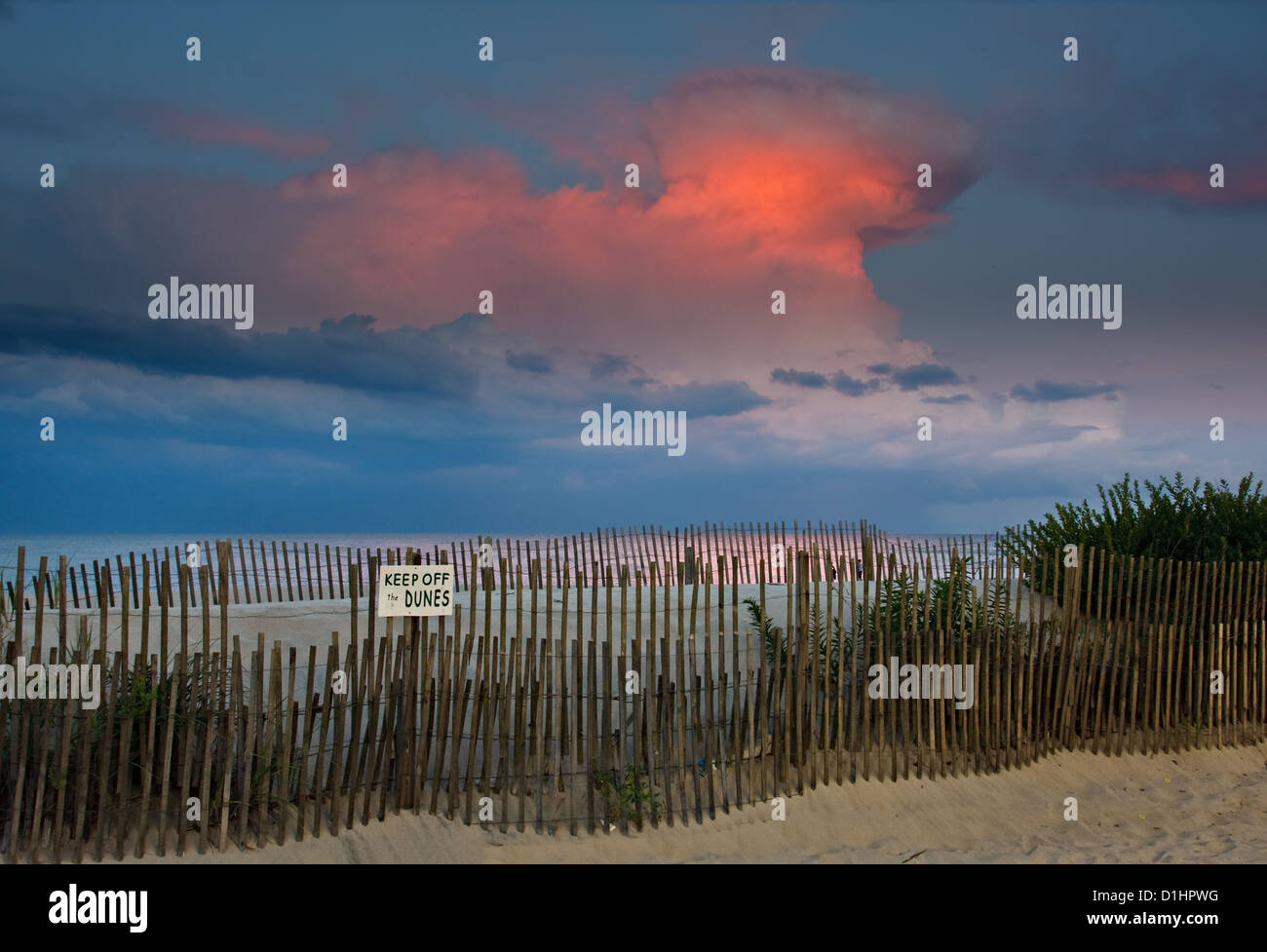 An evening scene at the beach. The last rays of light are dramatically lighting the clouds in the sky of a nearby thunderstorm. Stock Photo
