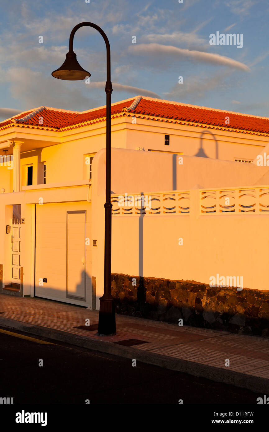 Evening sun sends a shadow of a lampost over three walls on the side of a villa in Tenerife, Canary Islands, Spain. Stock Photo