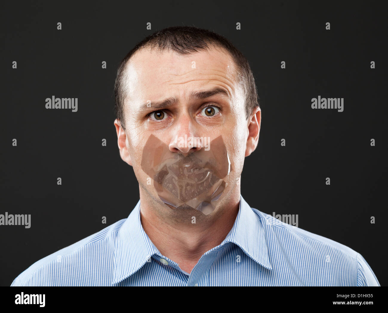 Conceptual image of a businessman with duct tape over his mouth Stock