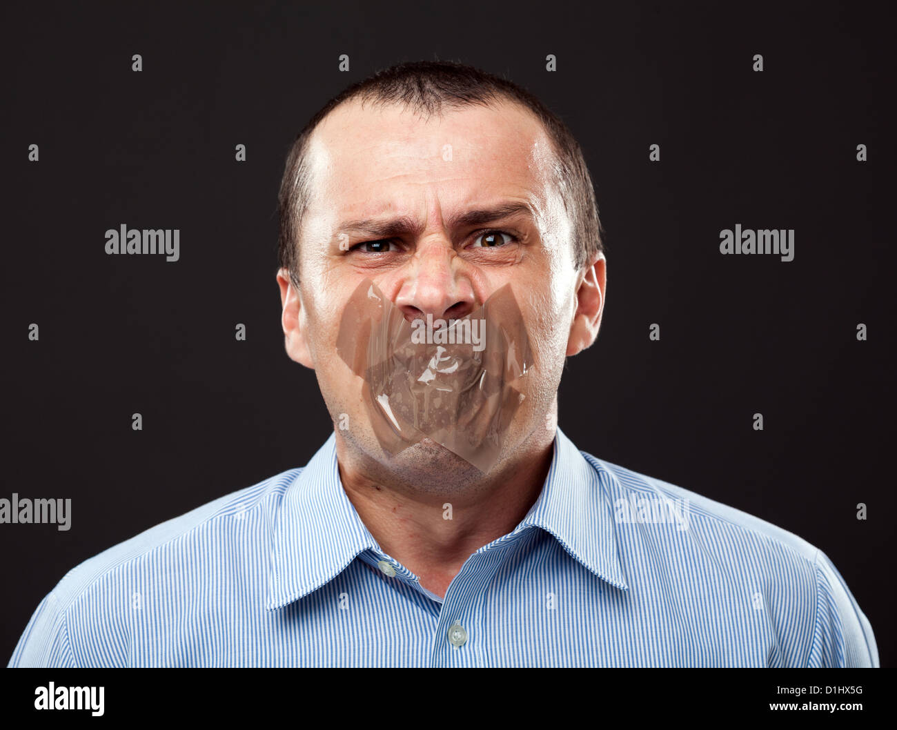 Conceptual image of a businessman with duct tape over his mouth Stock