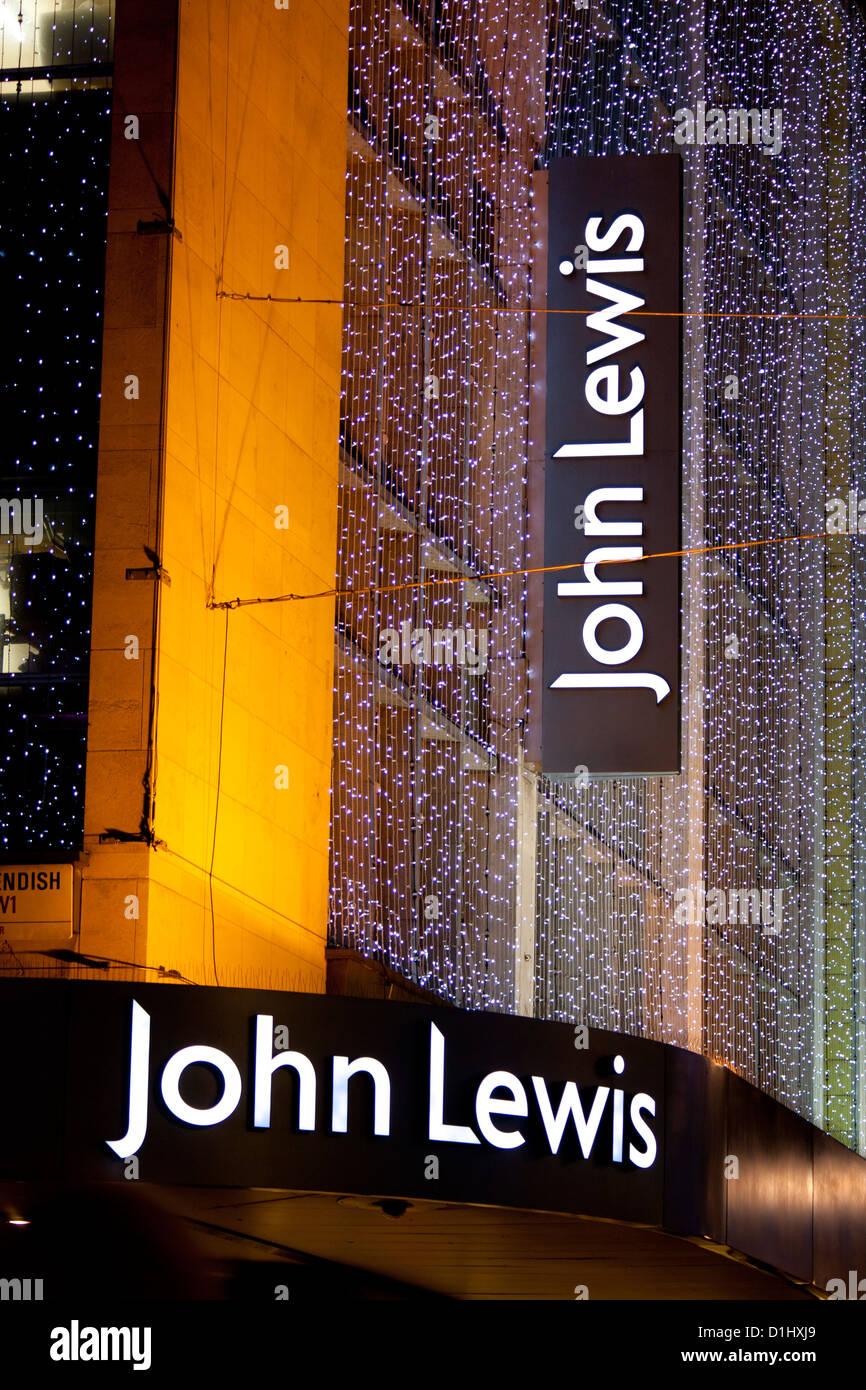 John Lewis department store signs with Christmas lighting / decorations at night Oxford Street London England UK Stock Photo