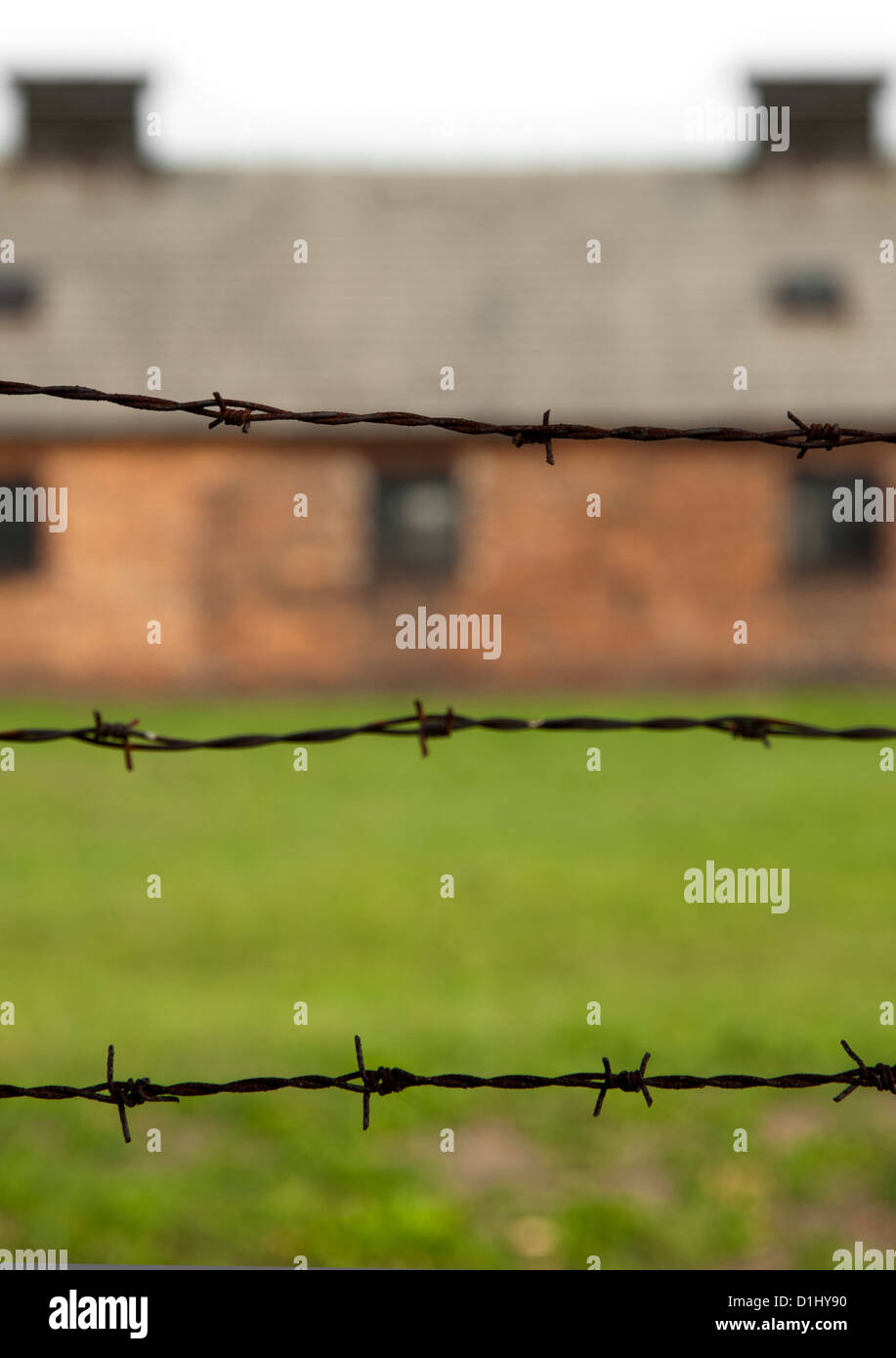 Barbed-wire fencing and buildings at the museum of the former Auschwitz II–Birkenau concentration camp in southern Poland. Stock Photo