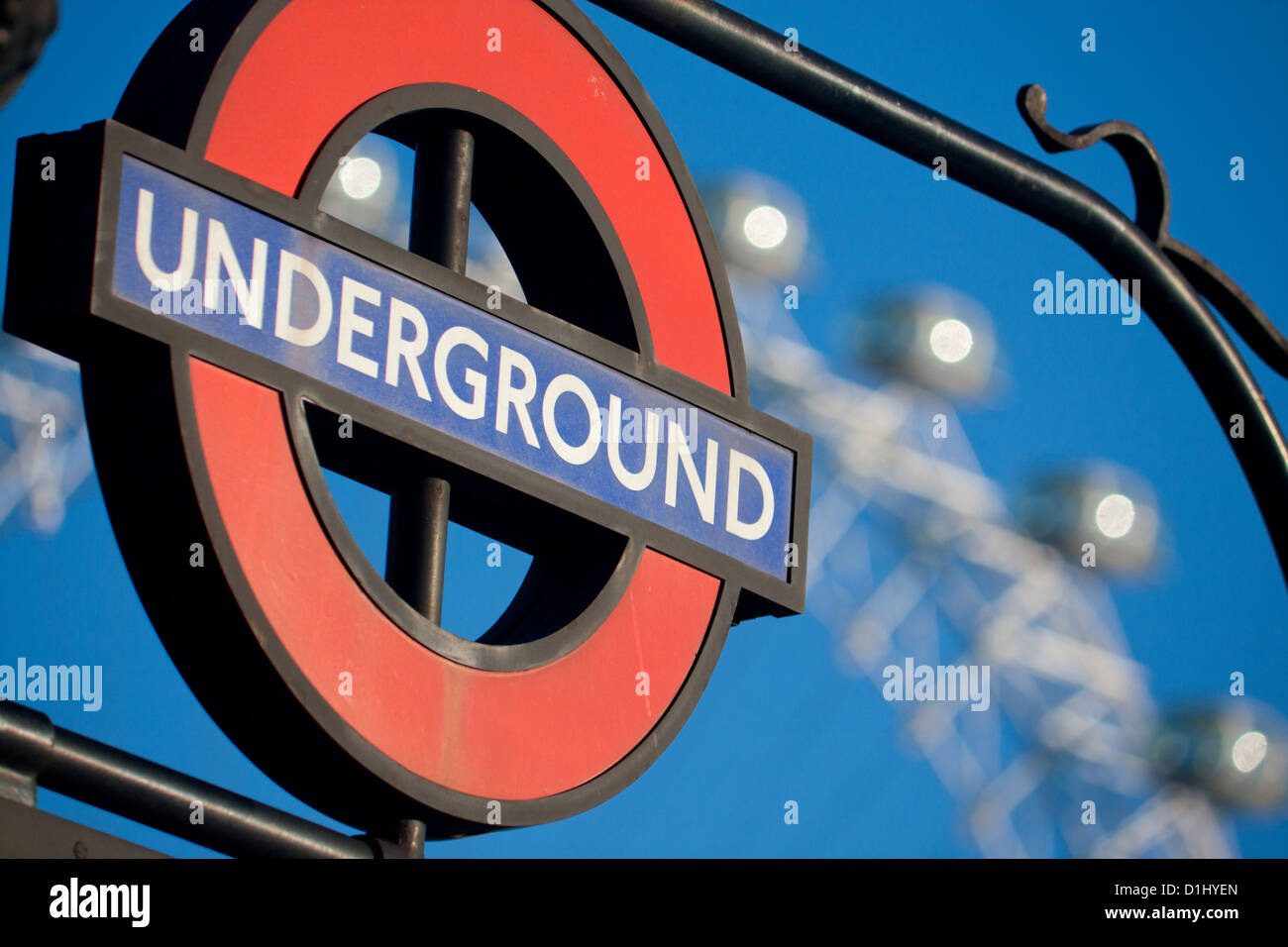 London Underground roundel at station entrance with London Eye ferris wheel framed Blue sky background London England UK Stock Photo