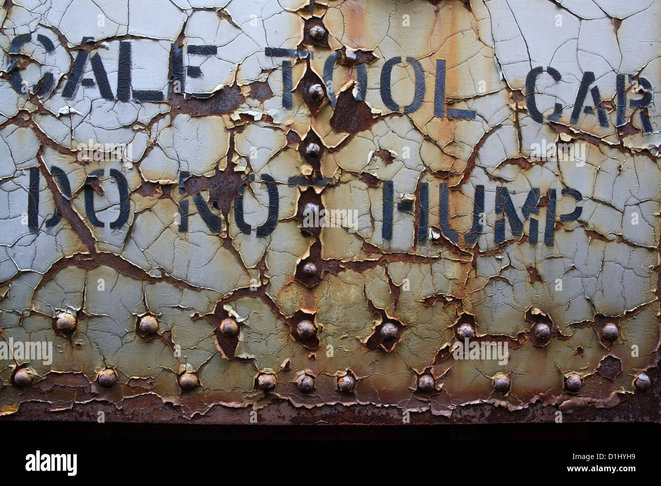 Peeling paint on railroad car, says "Do Not Hump", railroad train yard