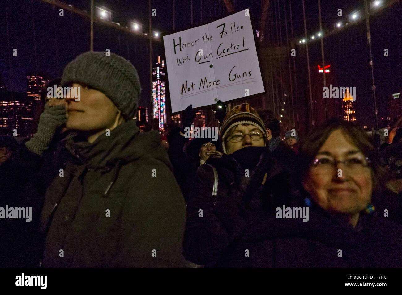 December 23, 2012, New York, NY, US. A man holds a sign reading 'Honor the fallen with gun control not more guns' during rally on the Brooklyn Bridge, nine days after the shooting rampage at Sandy Hook Elemetary School in nearby Newtown, Connecticut Stock Photo