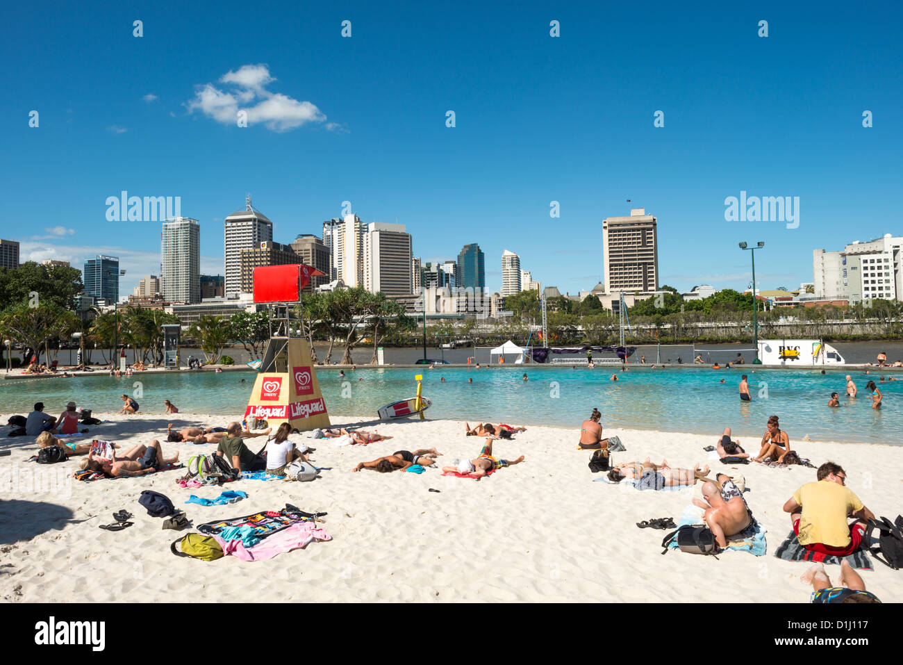 BRISBANE, Australia — The artificial beach at South Bank provides a popular recreational area directly across the Brisbane River from the city's central business district (CBD). Located within the South Bank Parklands, this man-made beach features sandy shores and swimming lagoons that offer respite from Queensland's subtropical climate. The parklands were developed on the site of World Expo '88 and have become a cultural and leisure hub in Queensland's capital city. Brisbane's distinctive skyline of modern high-rises forms the backdrop across the river. Stock Photo