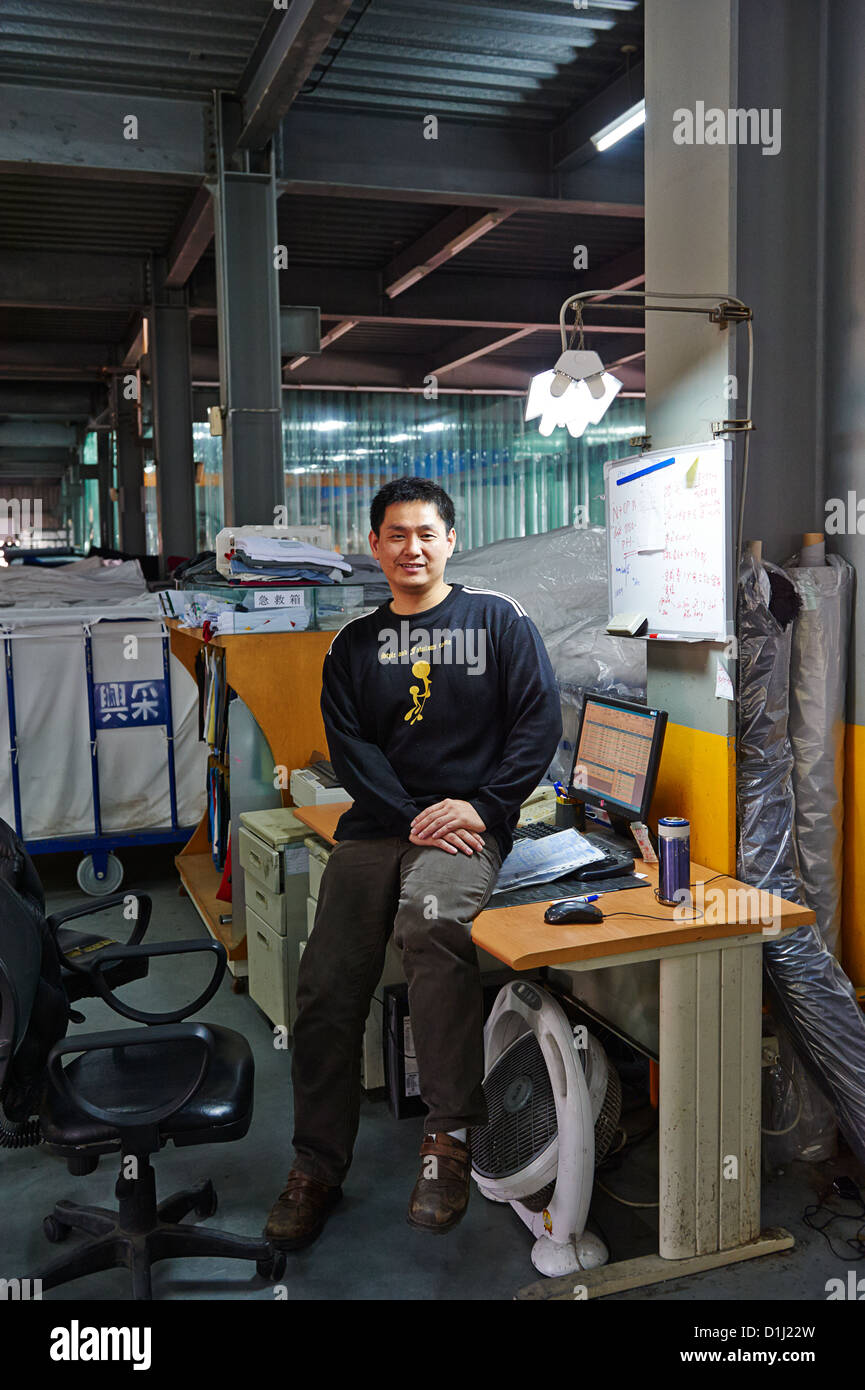 A worker at a textile lab poses next to a computer Stock Photo
