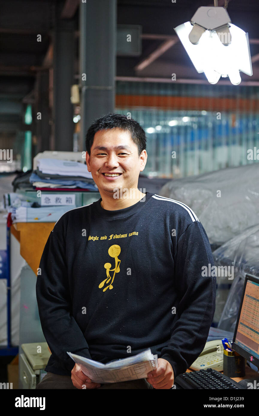 A worker at a textile lab poses next to a computer Stock Photo