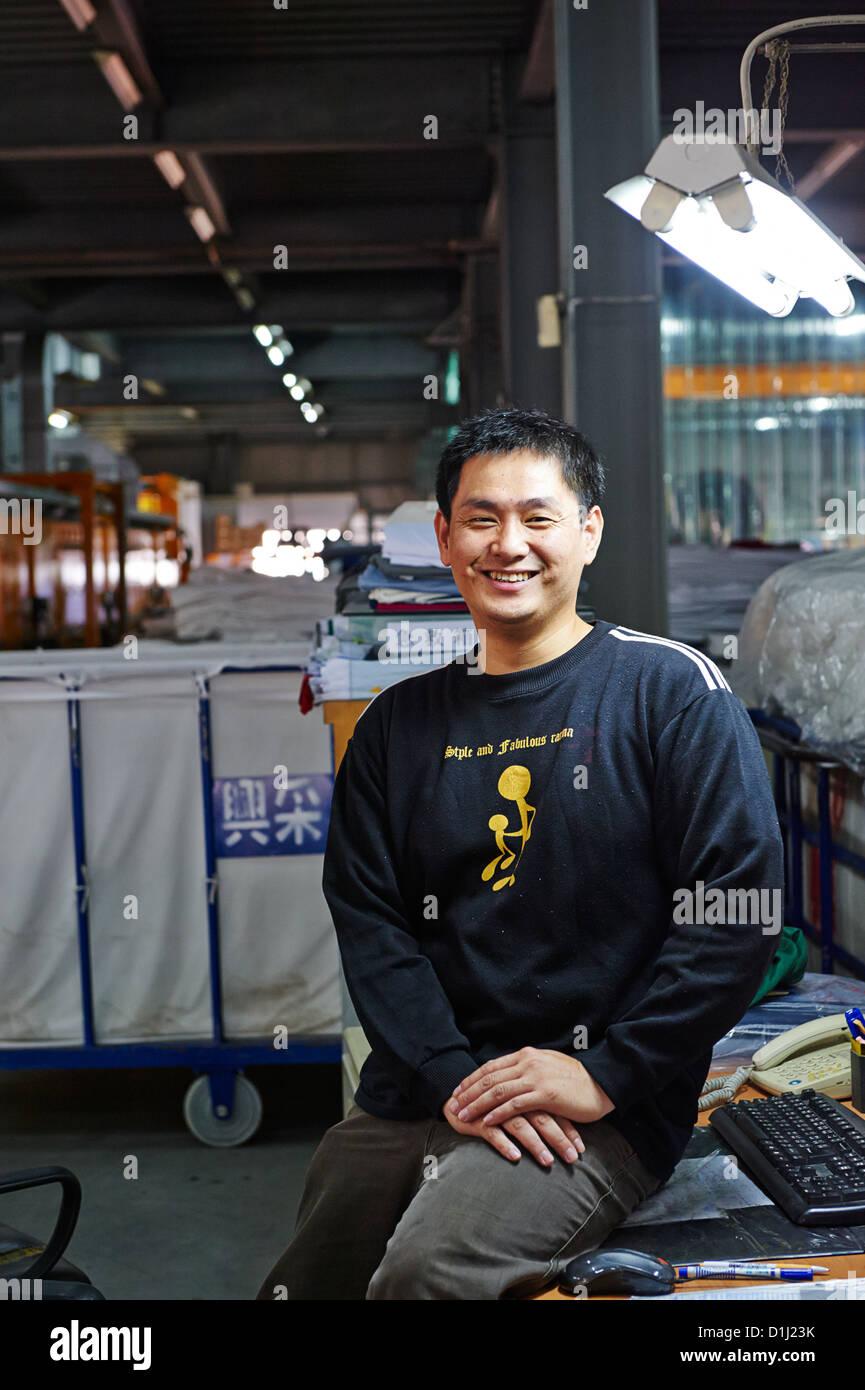 A worker at a textile lab poses next to a computer Stock Photo