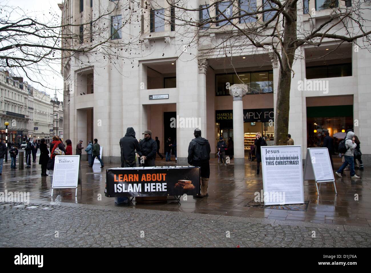 London, UK. 24th December 2012 A group of radical Muslims gather outside St Paul's Cathedral where they set up stalls and handed out leaflets with the intent to inform passers by of Islam.  There were various complaints to nearby police officers from the people queuing nearby to enter St Paul’s Cathedral where they were attending a service. Stock Photo