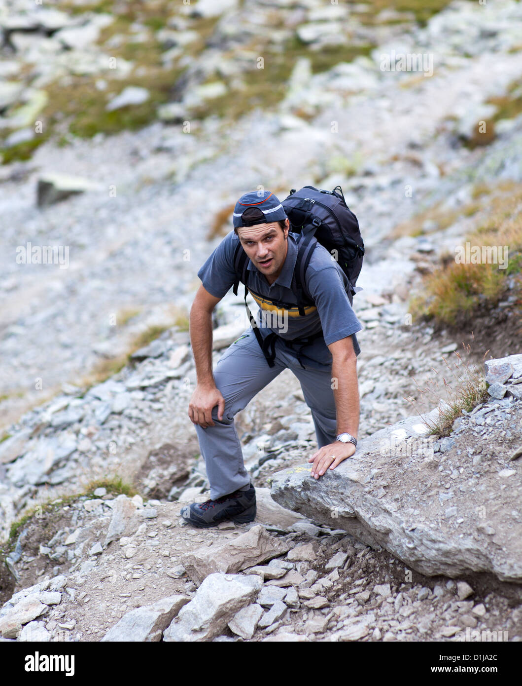 Young man hiking on mountain trail Stock Photo - Alamy