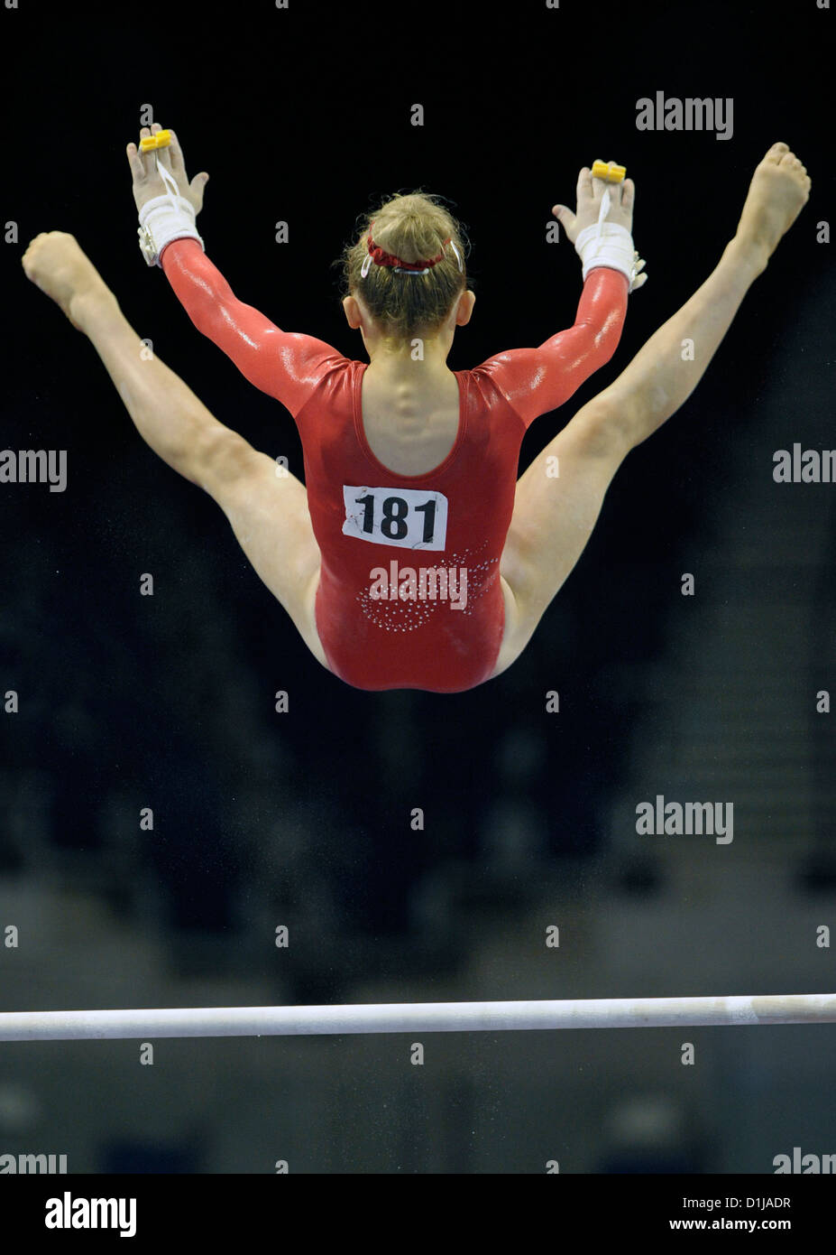 A  female gymnast performs a release and catch move on the uneven bars during the British Gymnastics Championships at the E Stock Photo