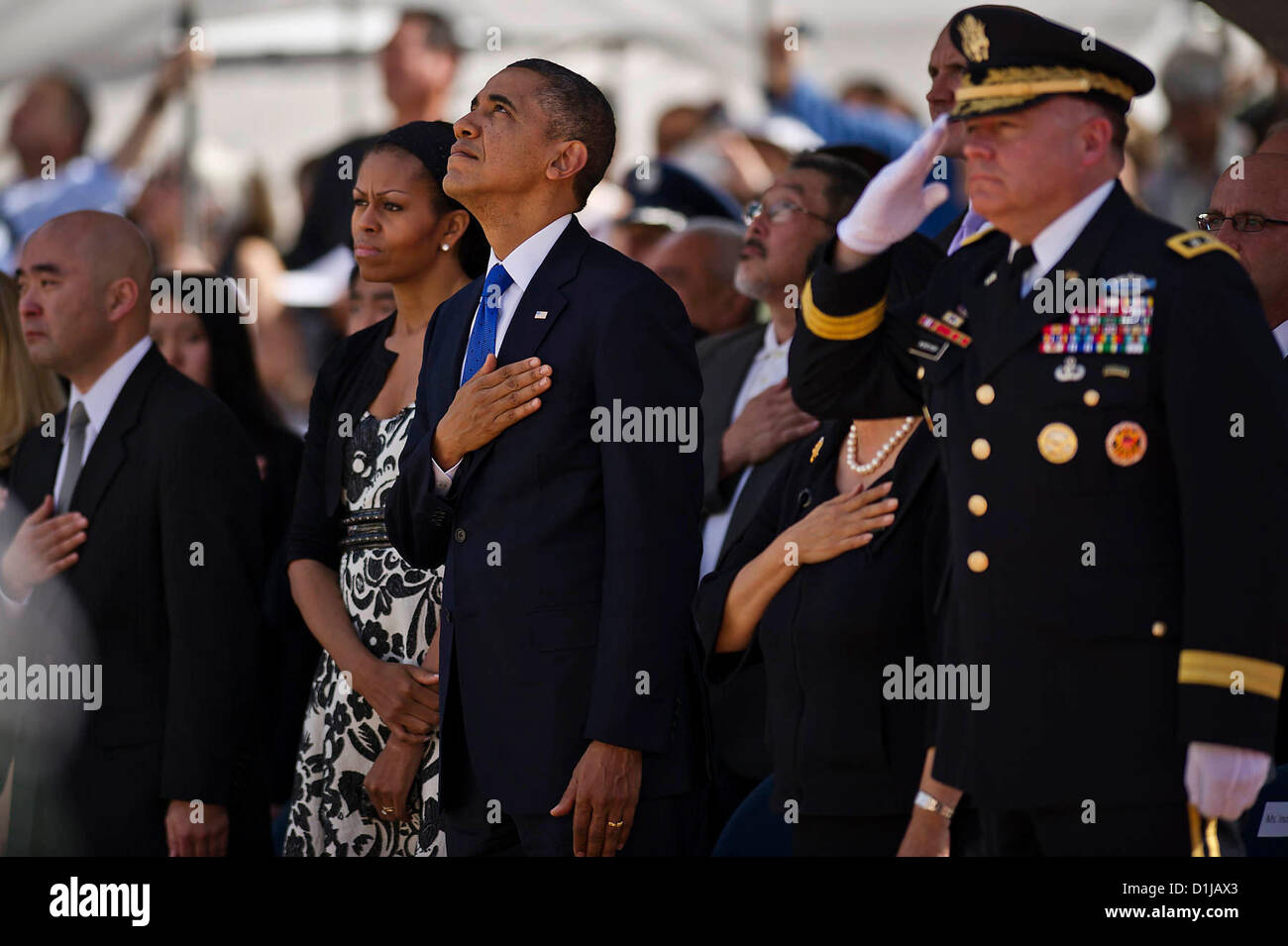 US President Barack Obama looks toward the sky as Air Force F-22 Raptors perform the missing man formation in honor of Senator Daniel Inouye during a memorial service at the National Memorial Cemetery of the Pacific December 23, 2012 in Honolulu, HI. Stock Photo