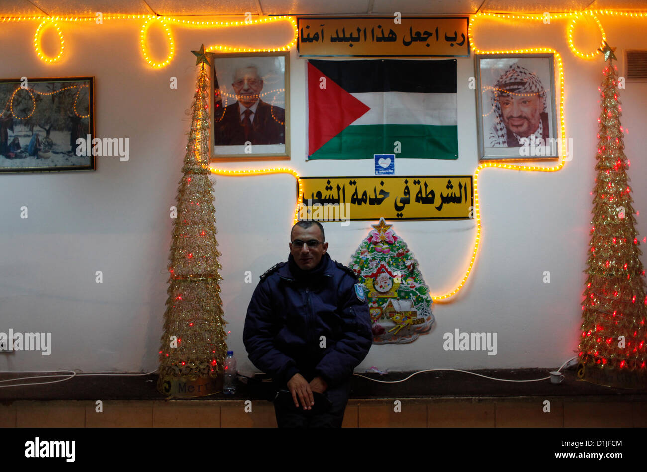 A Palestinian policeman with Christmas decorations sits in a Police station in Manger Square, in the West Bank town of Bethlehem in the Autonomous Palestinian Authority Stock Photo