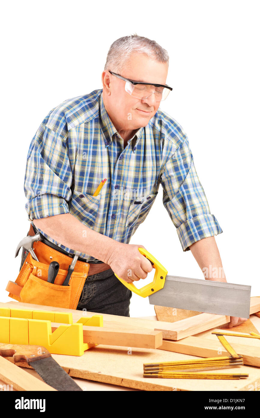 Carpenter cutting wooden batten with a saw isolated on white background Stock Photo
