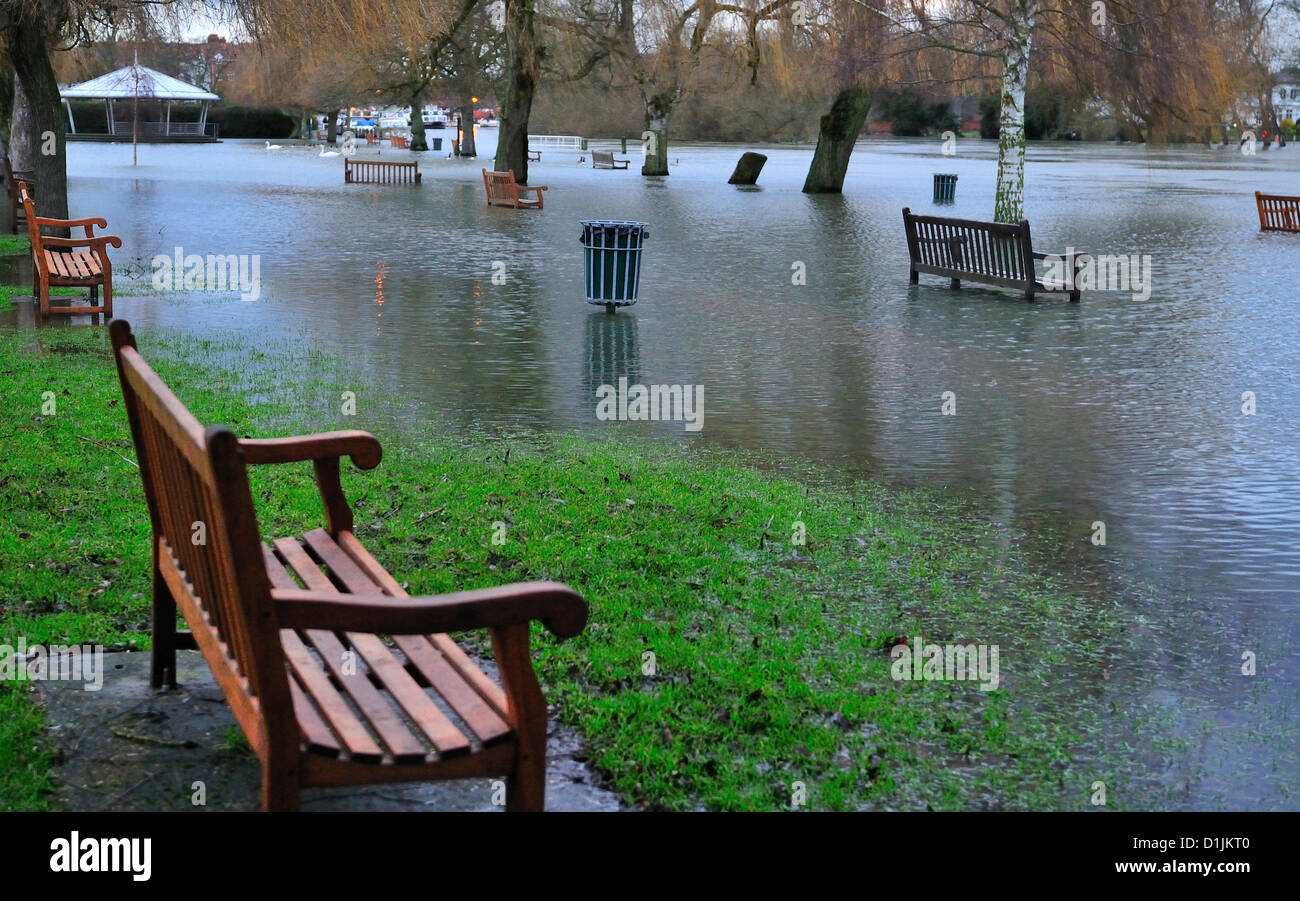 Henley-on-Thames Buckinghamshire   UK   16.00 GMT  20-12-2012    Traditional Christmas Day strolls along the Thames side tow path  and feeding the ducks at Mill Meadows ,Henley-on-Thames,  thwarted by the rising flood waters (Note  the river Thames is between the bench and the Berkshire side of the river -as seen) the band stand in normally on Mill Meadows green Stock Photo