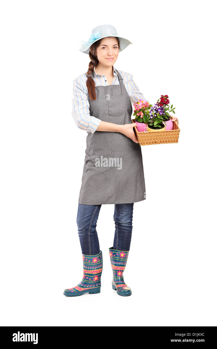 Full length portrait of a female gardener holding flower plants ...