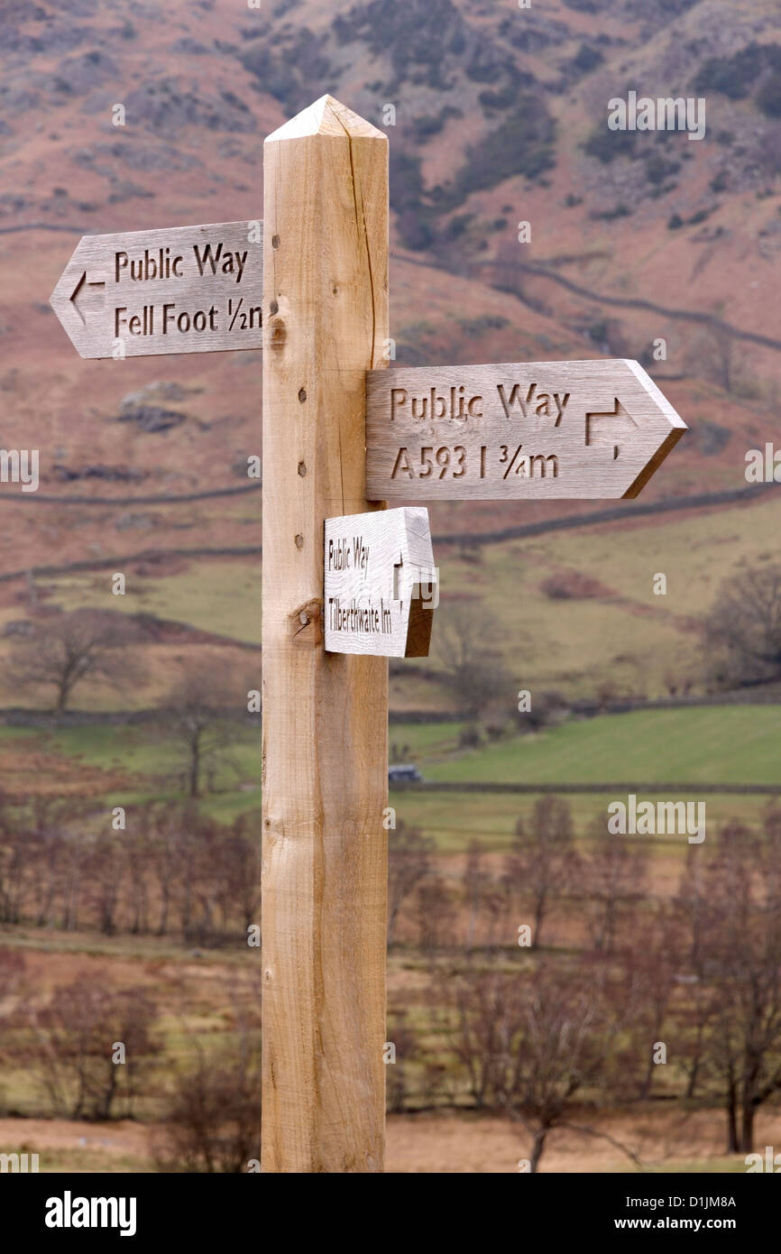 Carved wooden footpath direction finger post sign in Little Langdale, Cumbria, Lake District, England, UK. Stock Photo