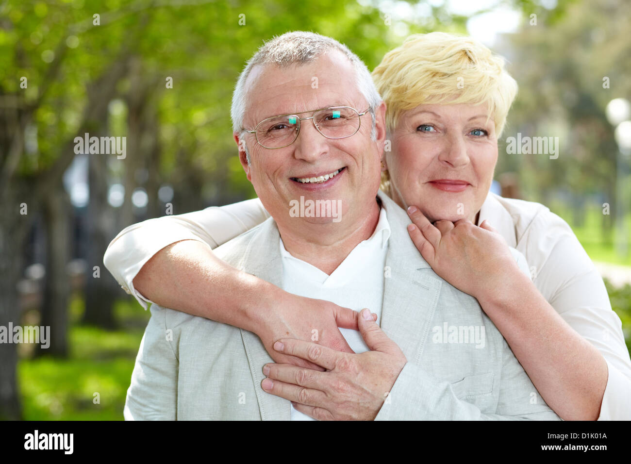 Portrait of happy mature woman hugging her husband outside Stock Photo