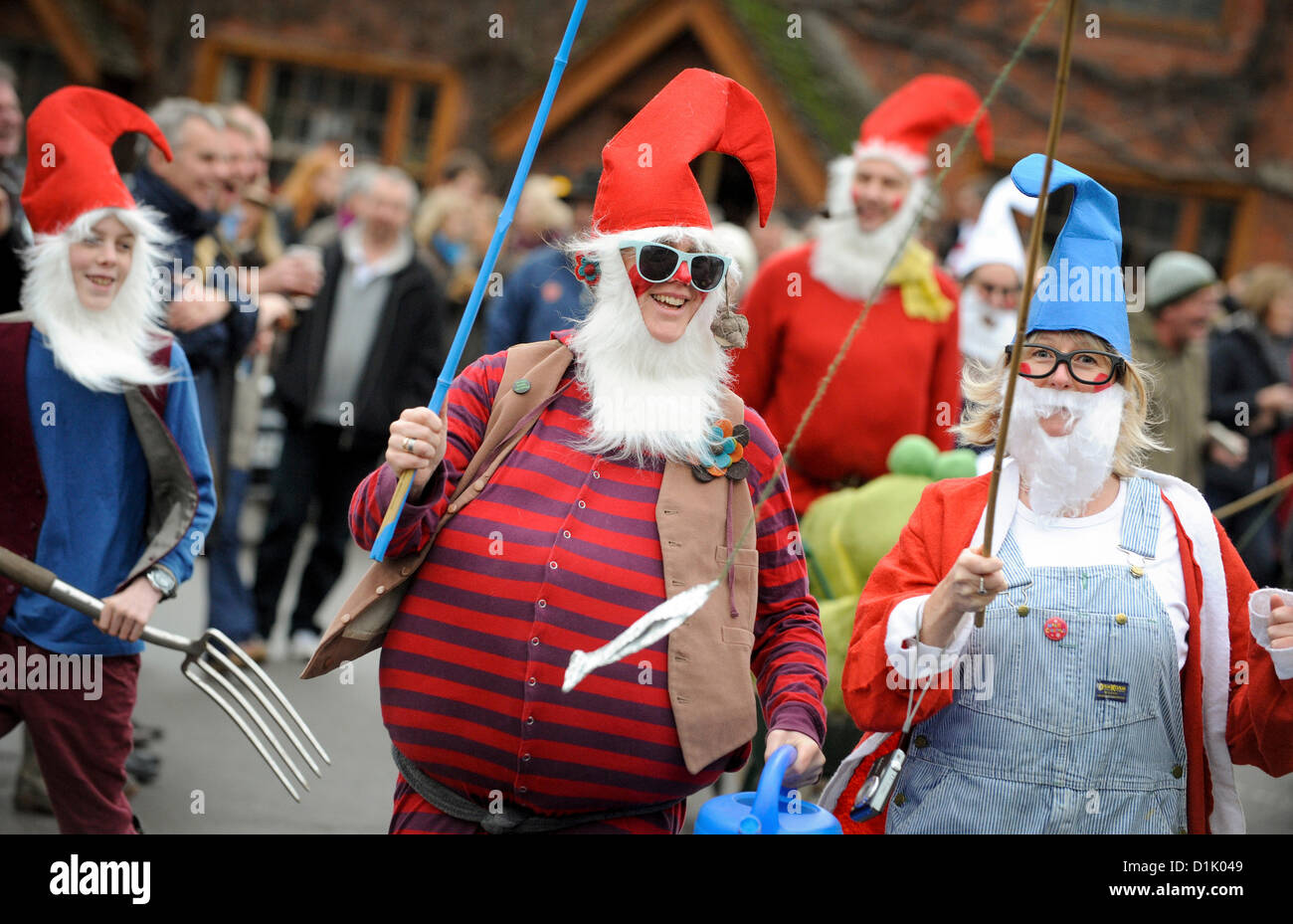 East Hoathly, UK. 26th December 2012. East Hoathly Boxing Day pram race - crowds lined the East Sussex village High Street as teams gathered and raced their wacky machines between the two pubs for charity. A team of gnomes dash ahead with Kath Harrison leading her team. Credit:  Jim Holden / Alamy Live News Stock Photo