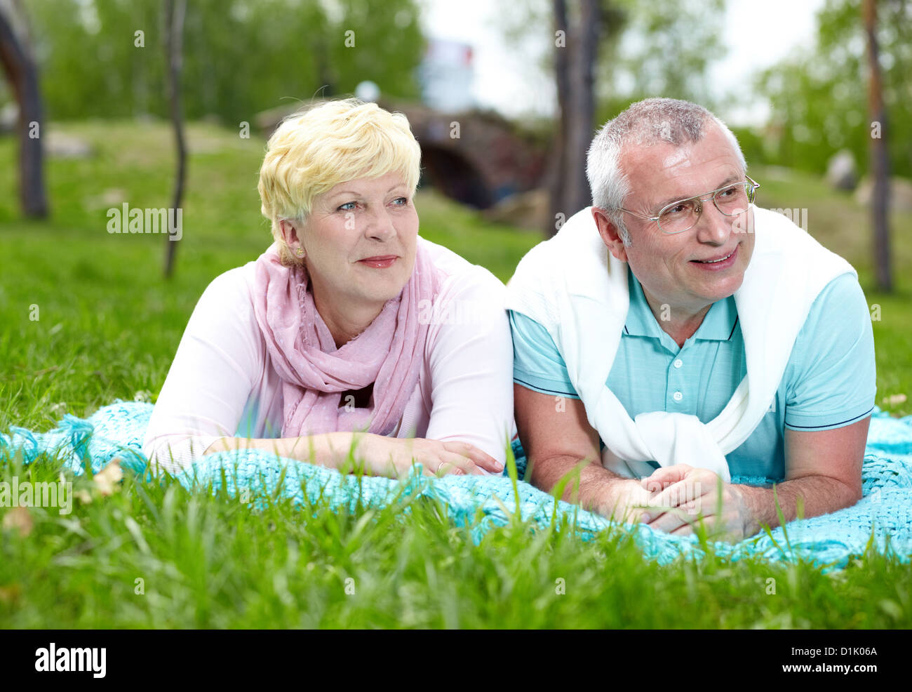 Happy mature couple lying on grass and having rest in summer Stock ...