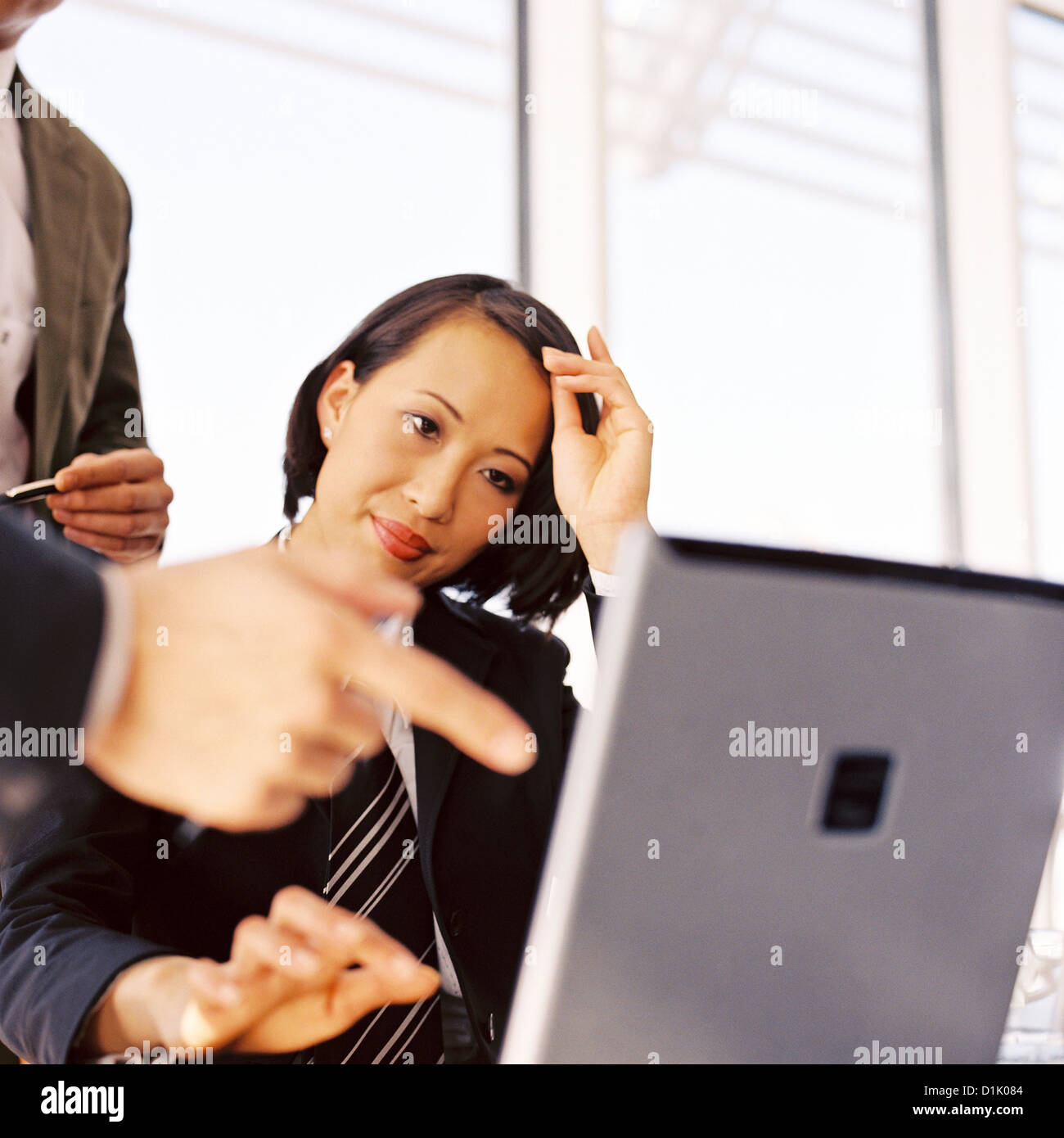 Businesswoman in office looking at laptop smiling License free except ads and billboards Stock Photo