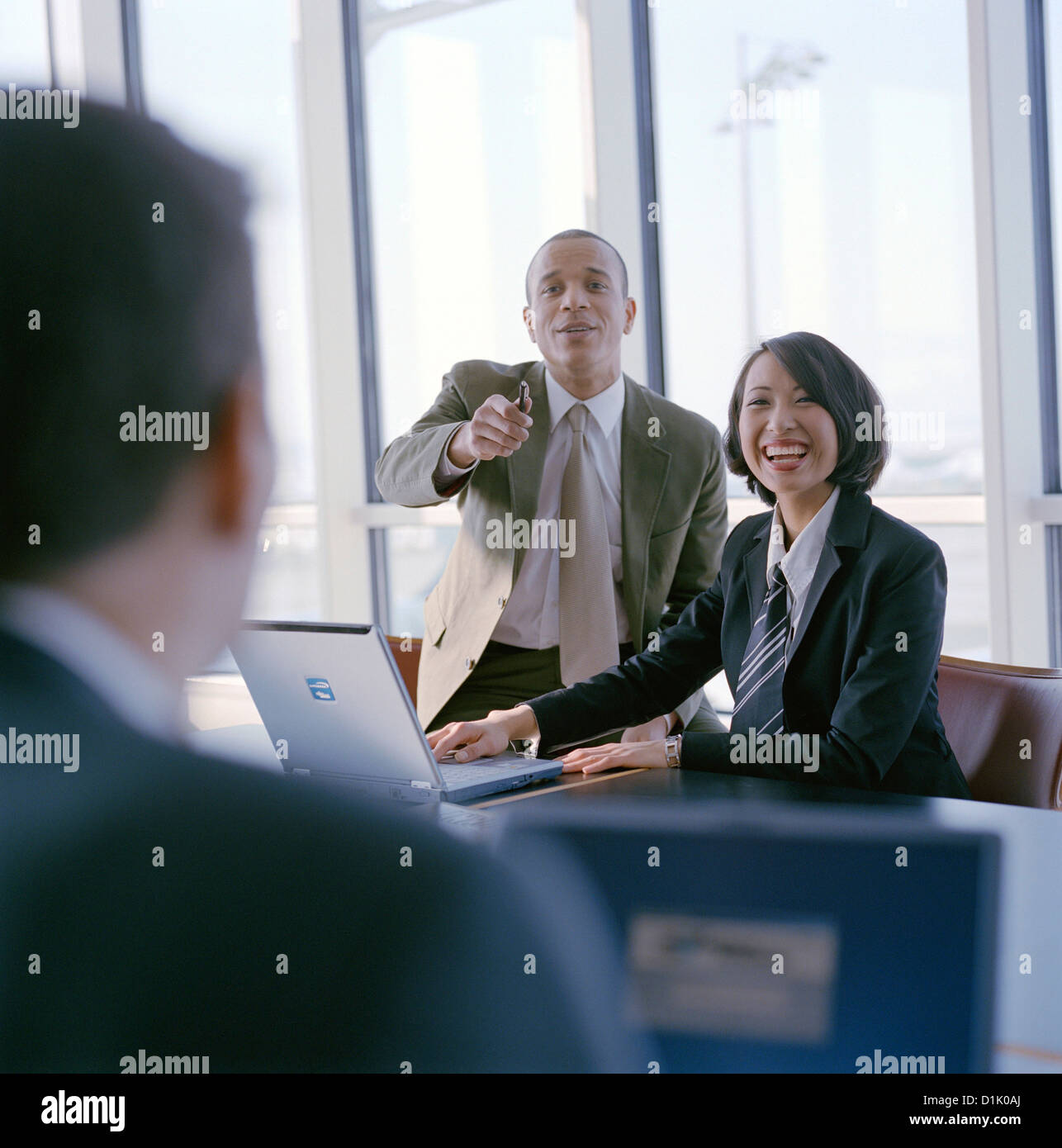 Smiling business people meeting at table in conference room with a Laptop License free except ads and billboards Stock Photo