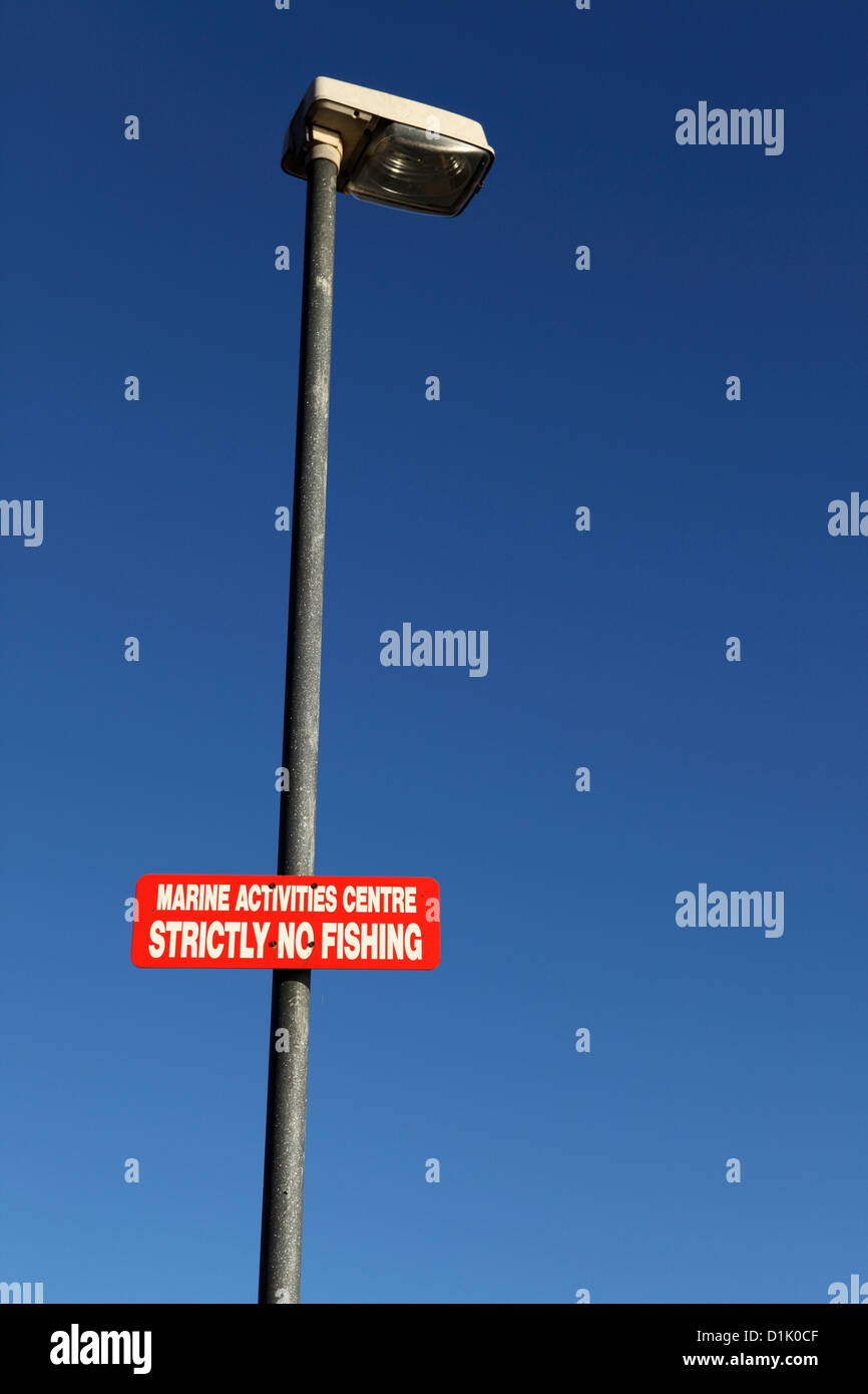 Lamp with a sign stating that fishing is not permitted. Stock Photo